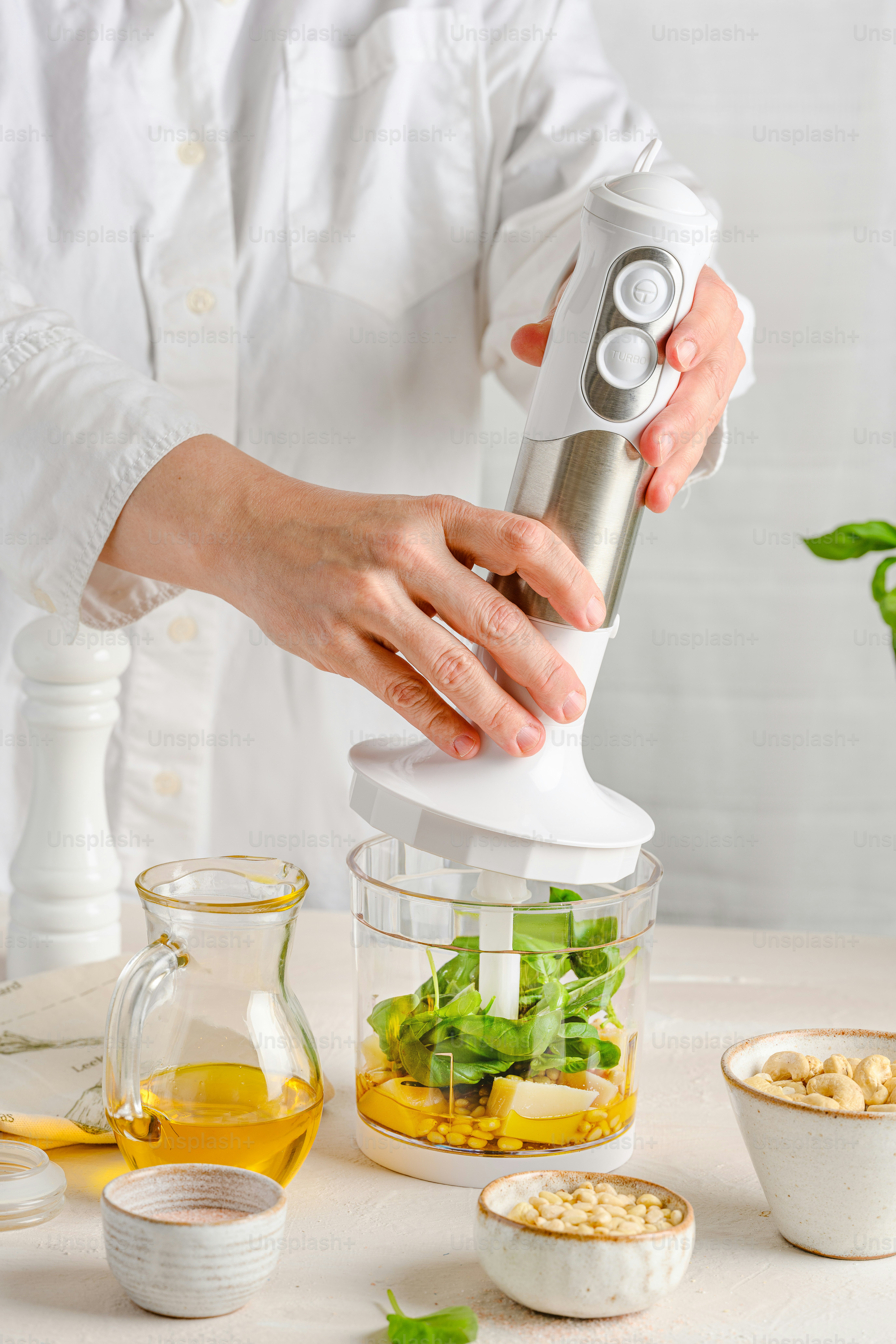 한 사람이 믹서기에 샐러드를 만들고 있습니다.
