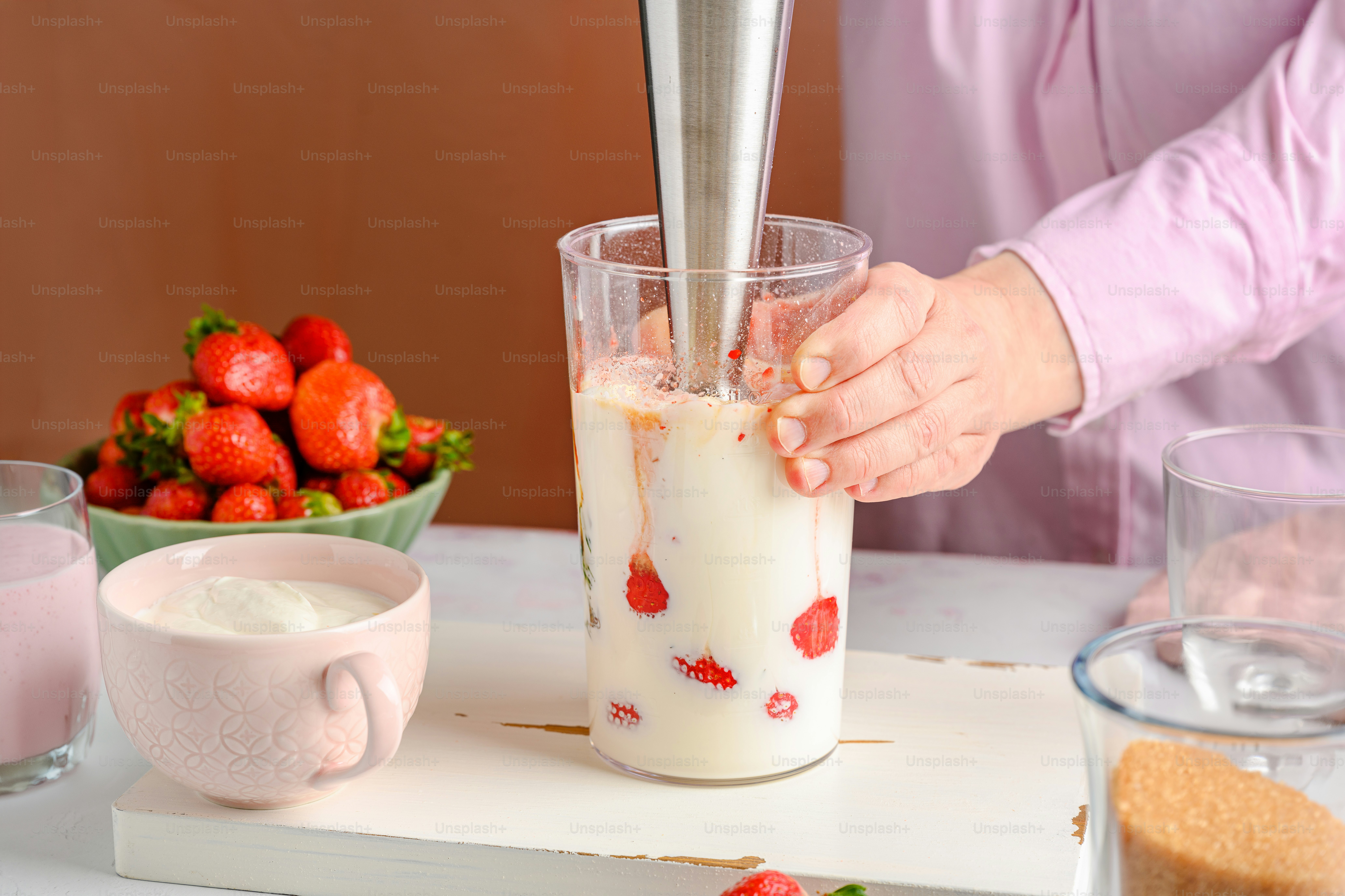 딸기를 배경으로 음료를 만드는 사람