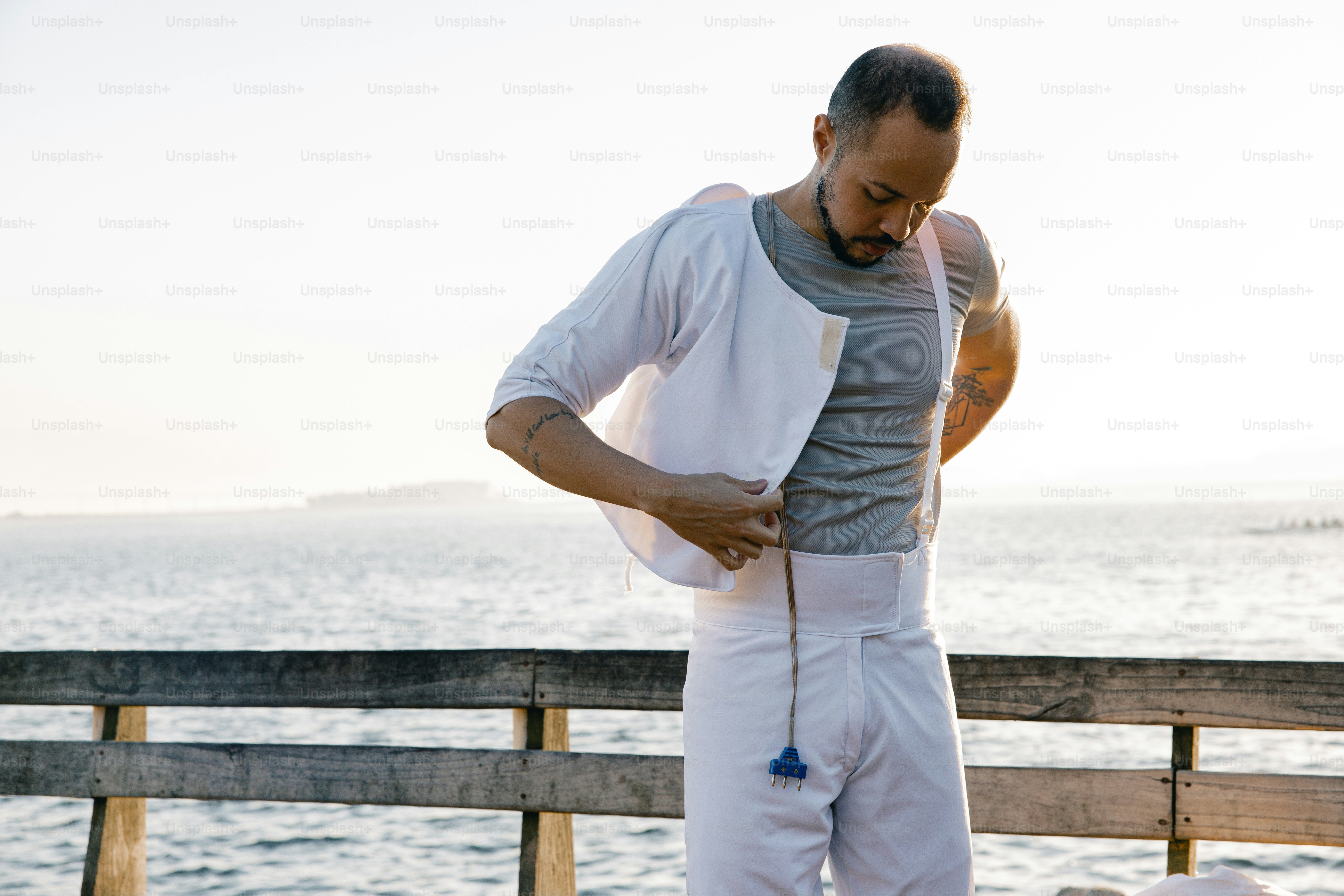 A man standing on a pier next to a dog