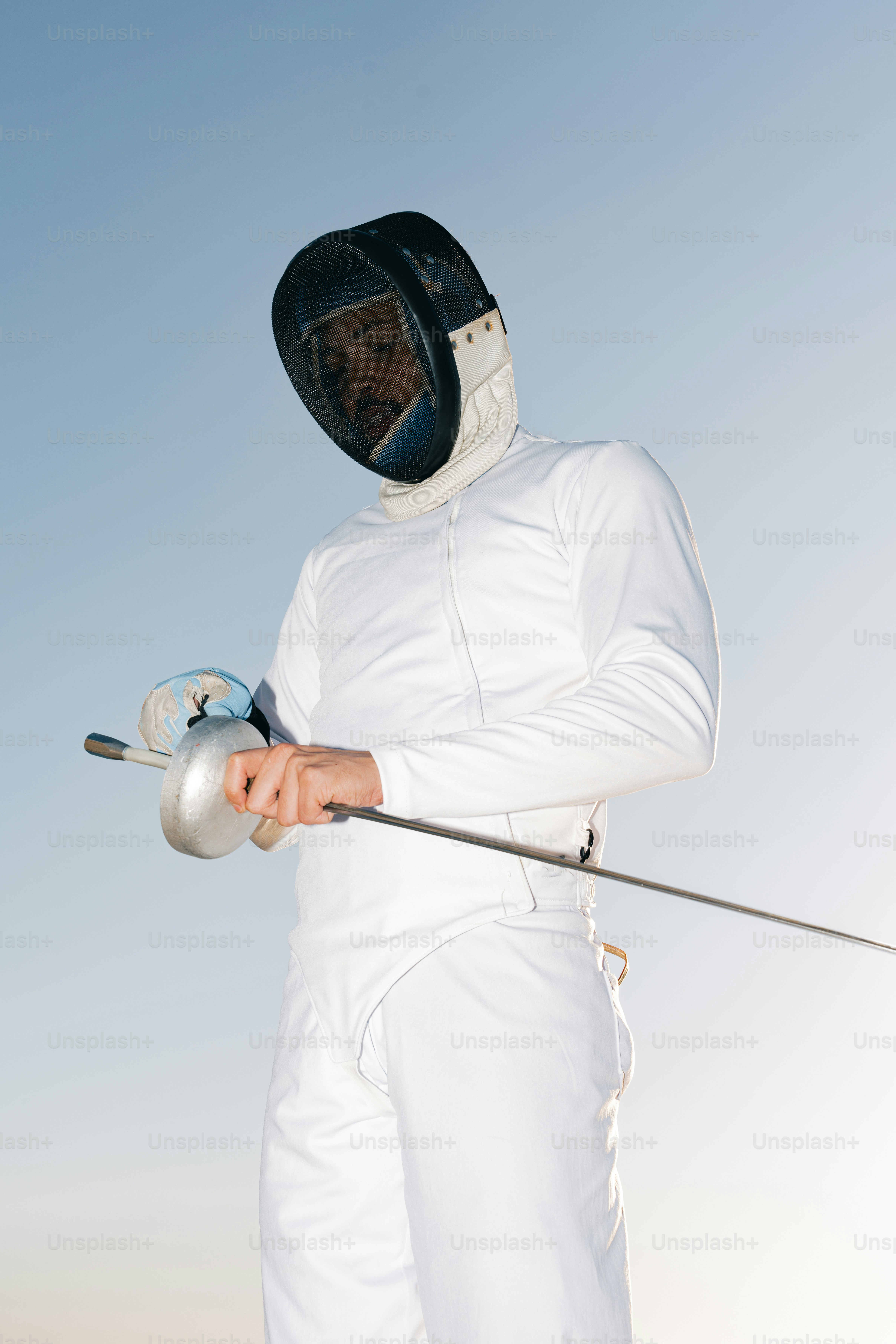 Um homem de terno branco segurando um objeto de metal