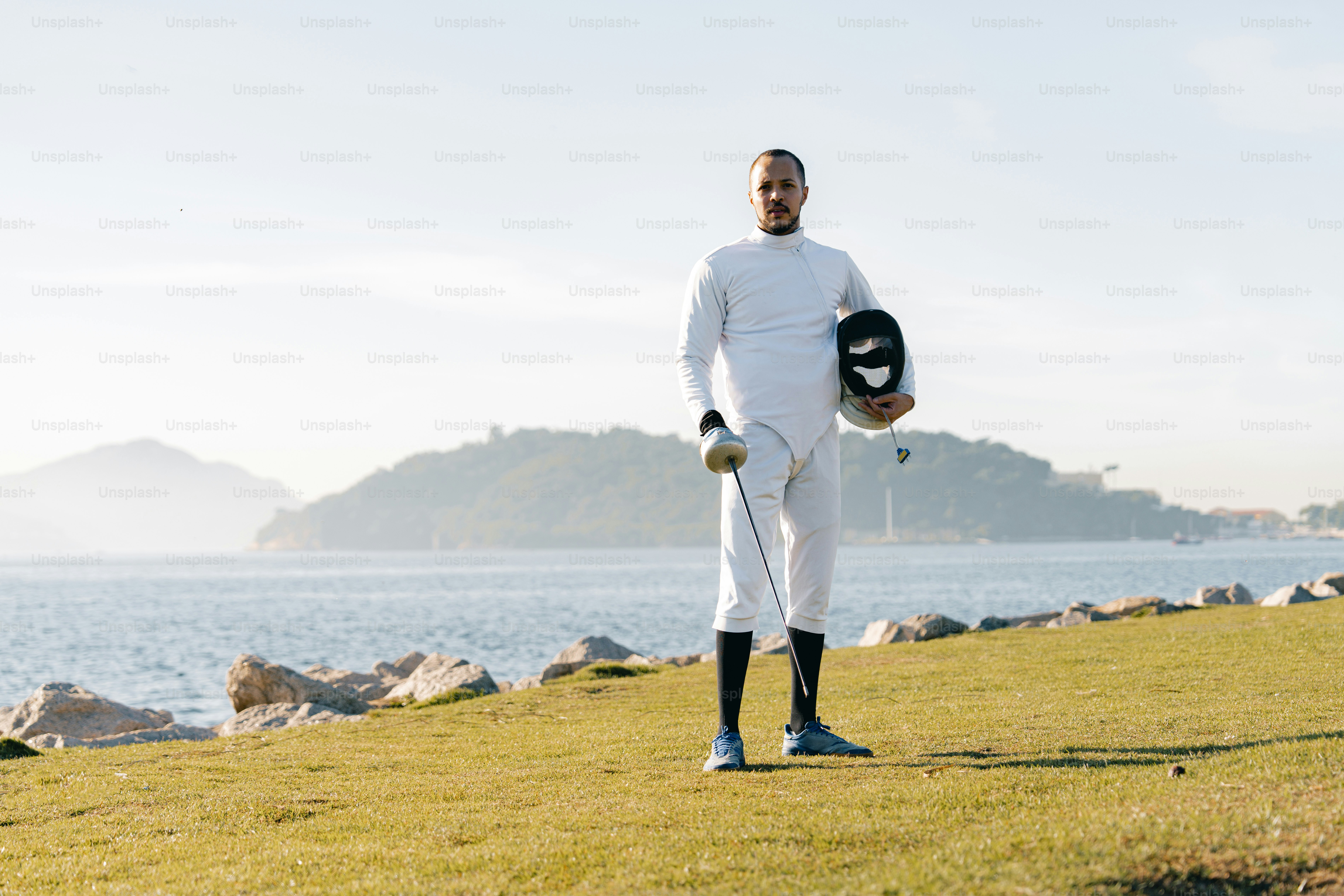 A man in a white outfit holding a helmet