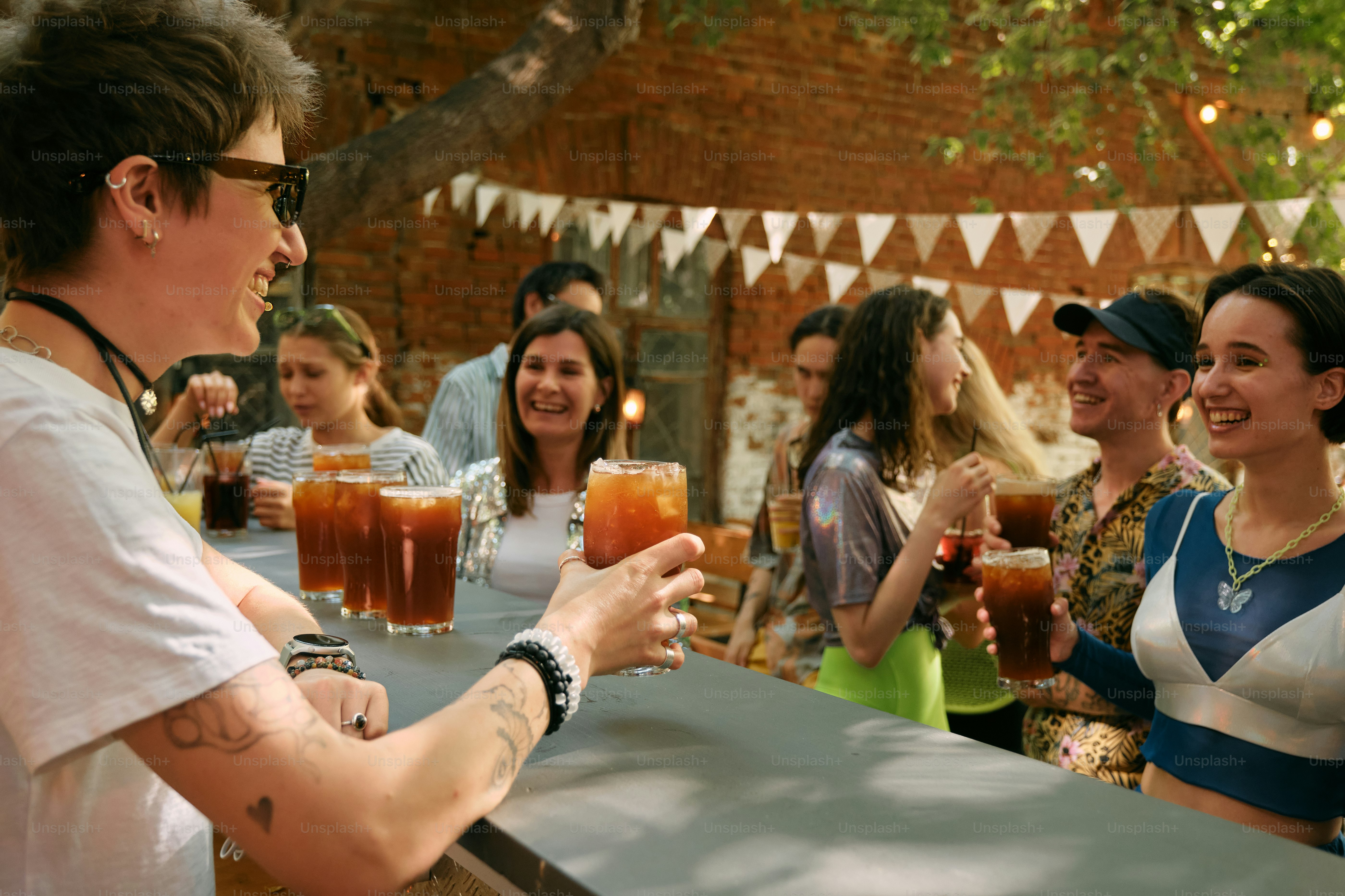 A group of people standing around a bar with drinks