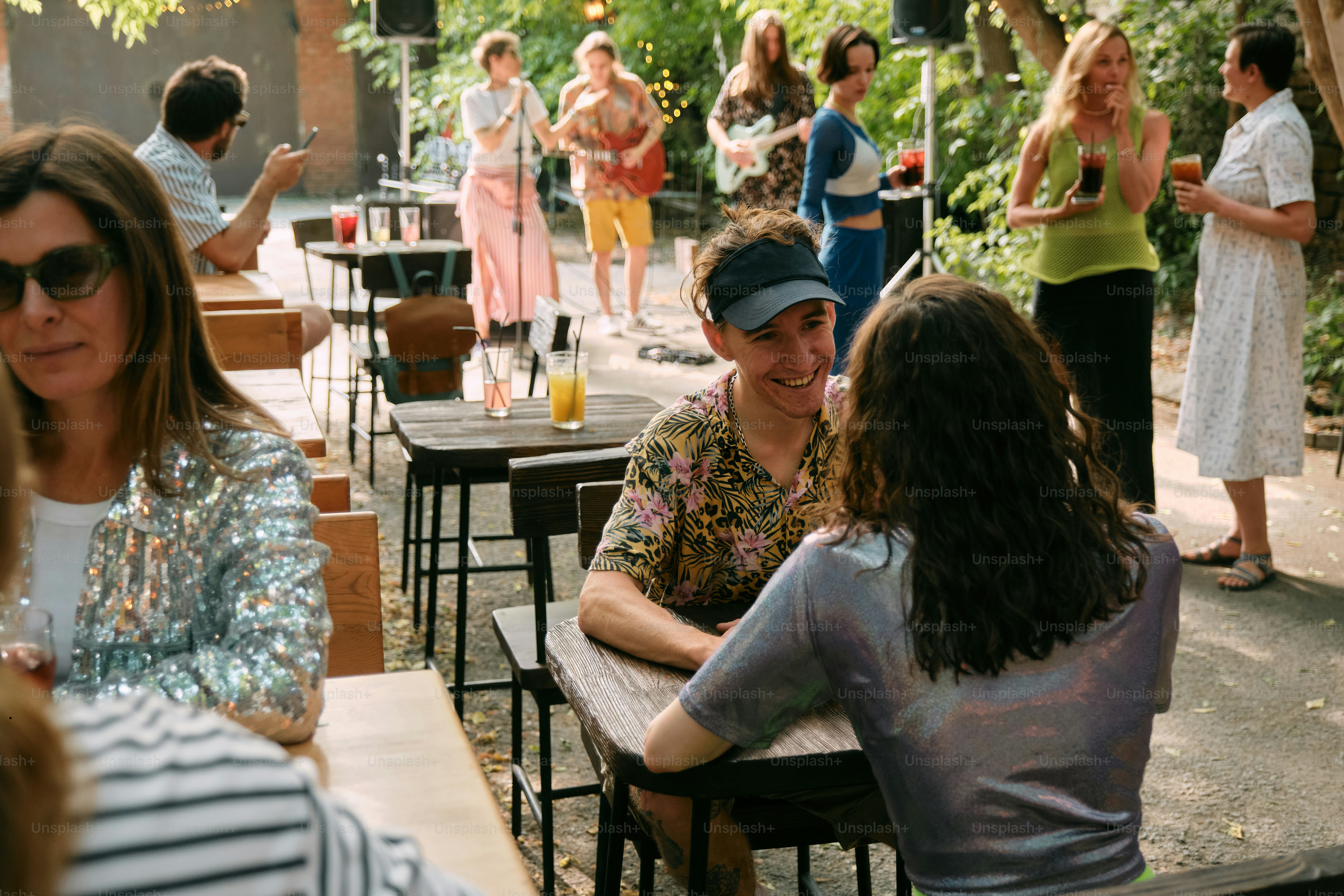 A group of people sitting at tables in a park