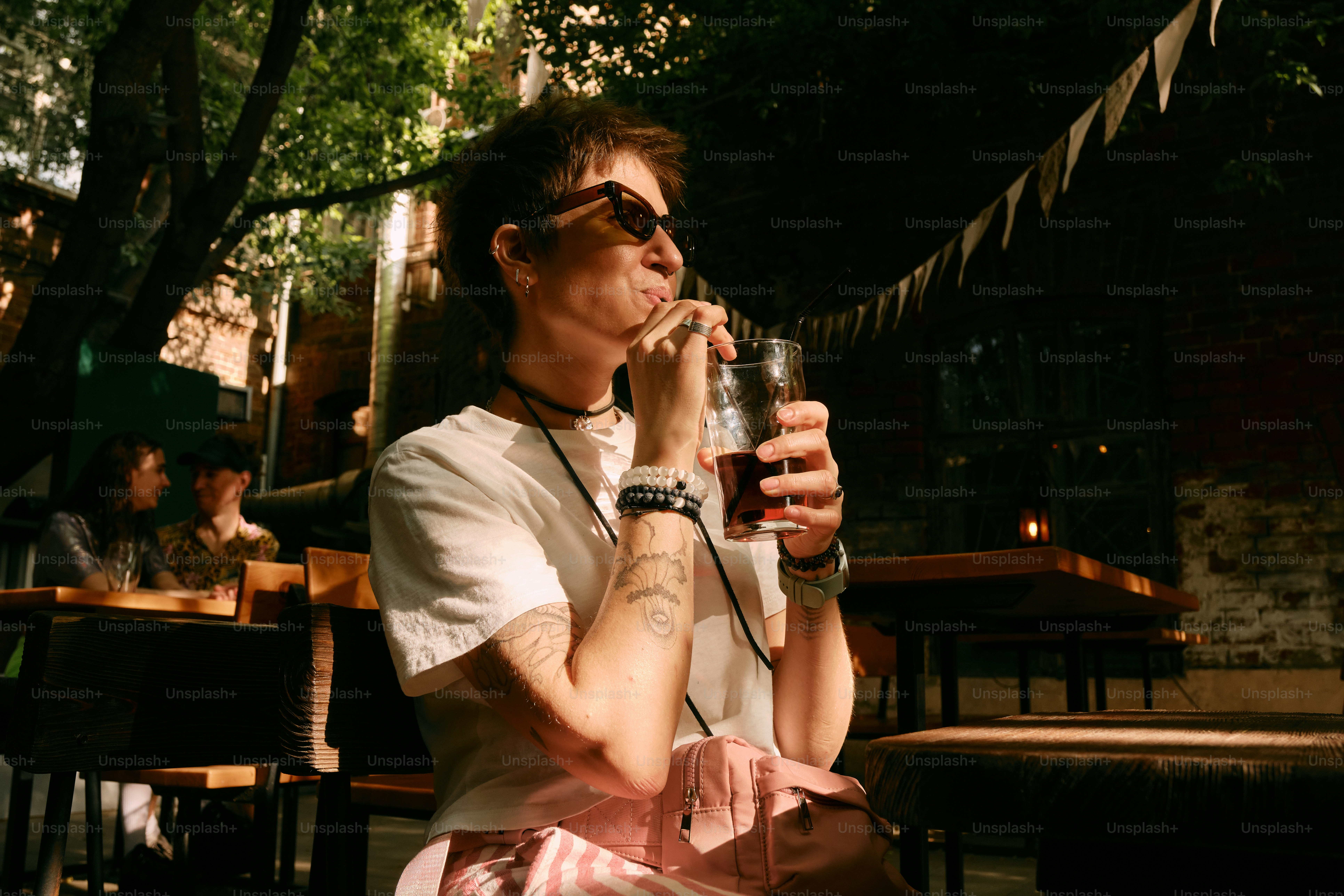 A man sitting on a bench drinking a glass of beer