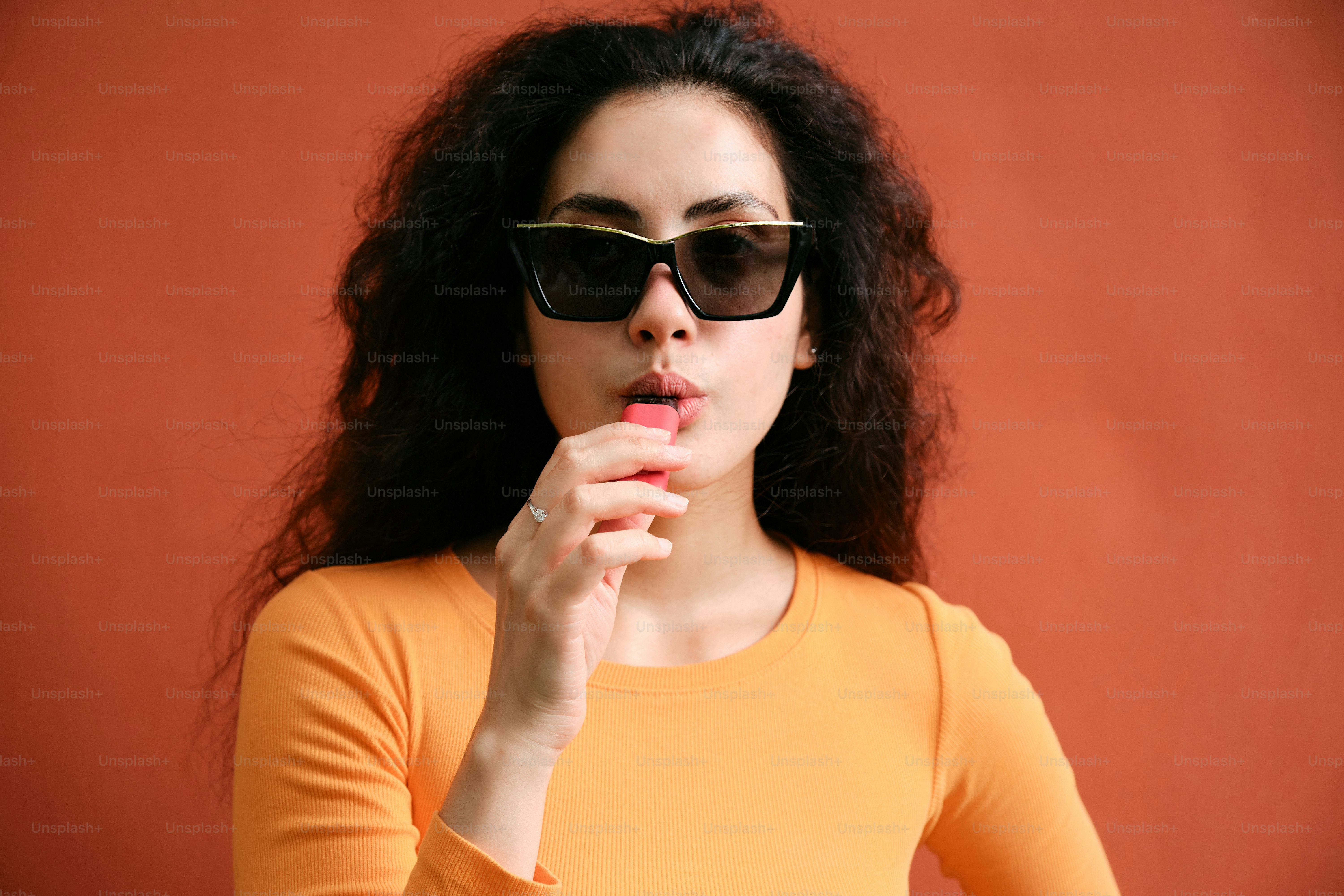A woman in a yellow shirt and black sunglasses