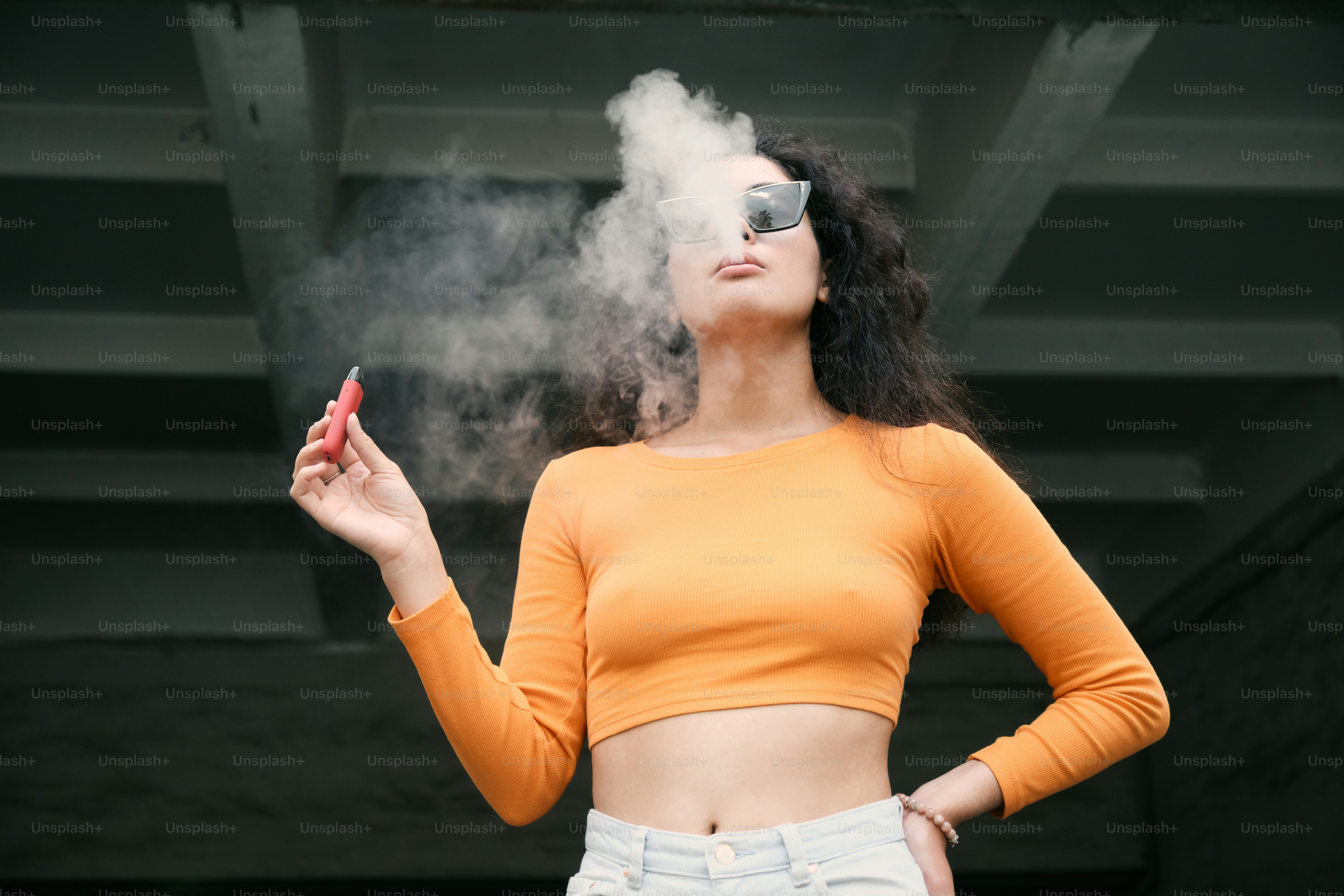 A woman smoking a cigarette in a yellow top