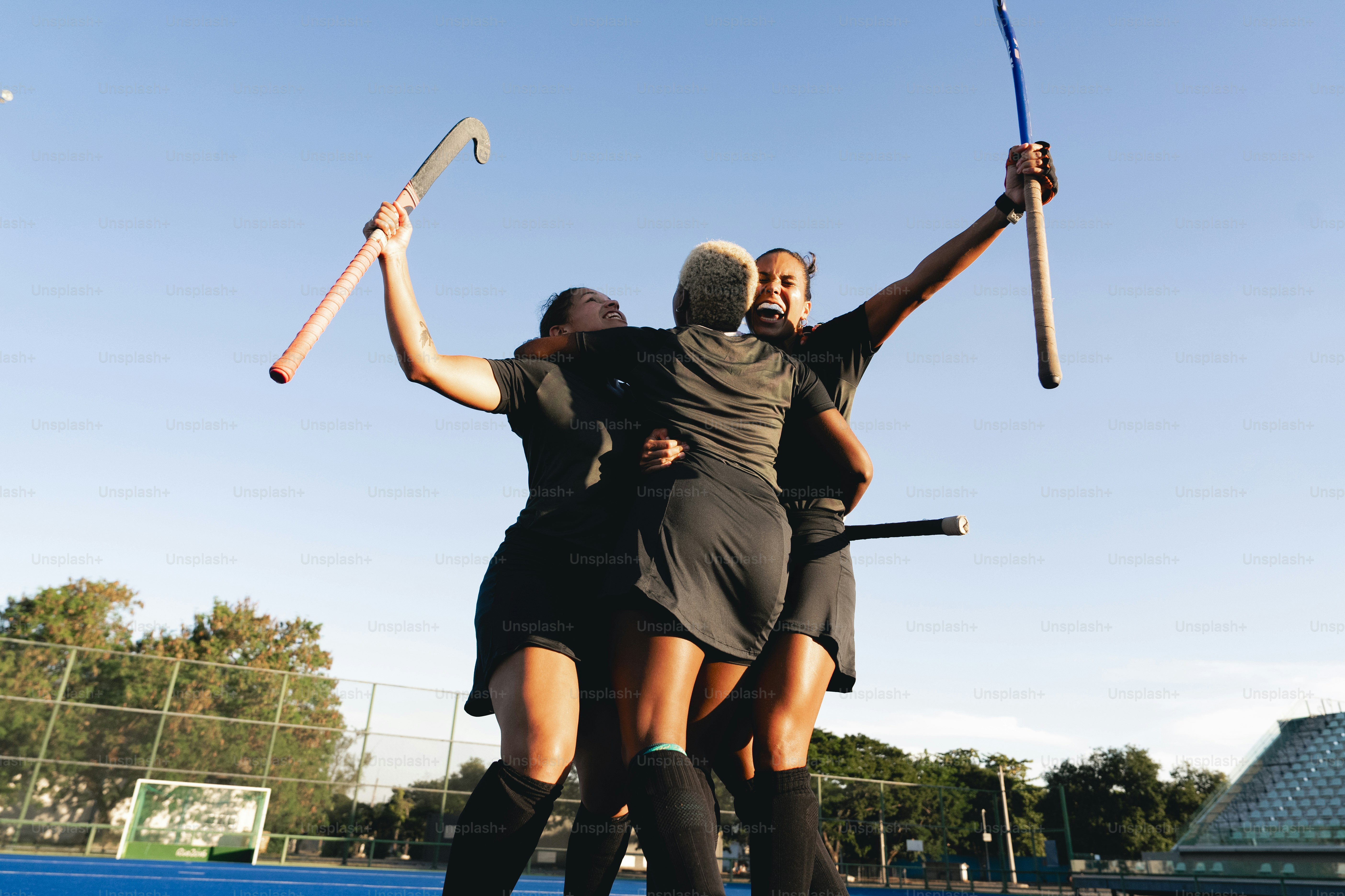 A group of women standing on top of a tennis court holding racquets