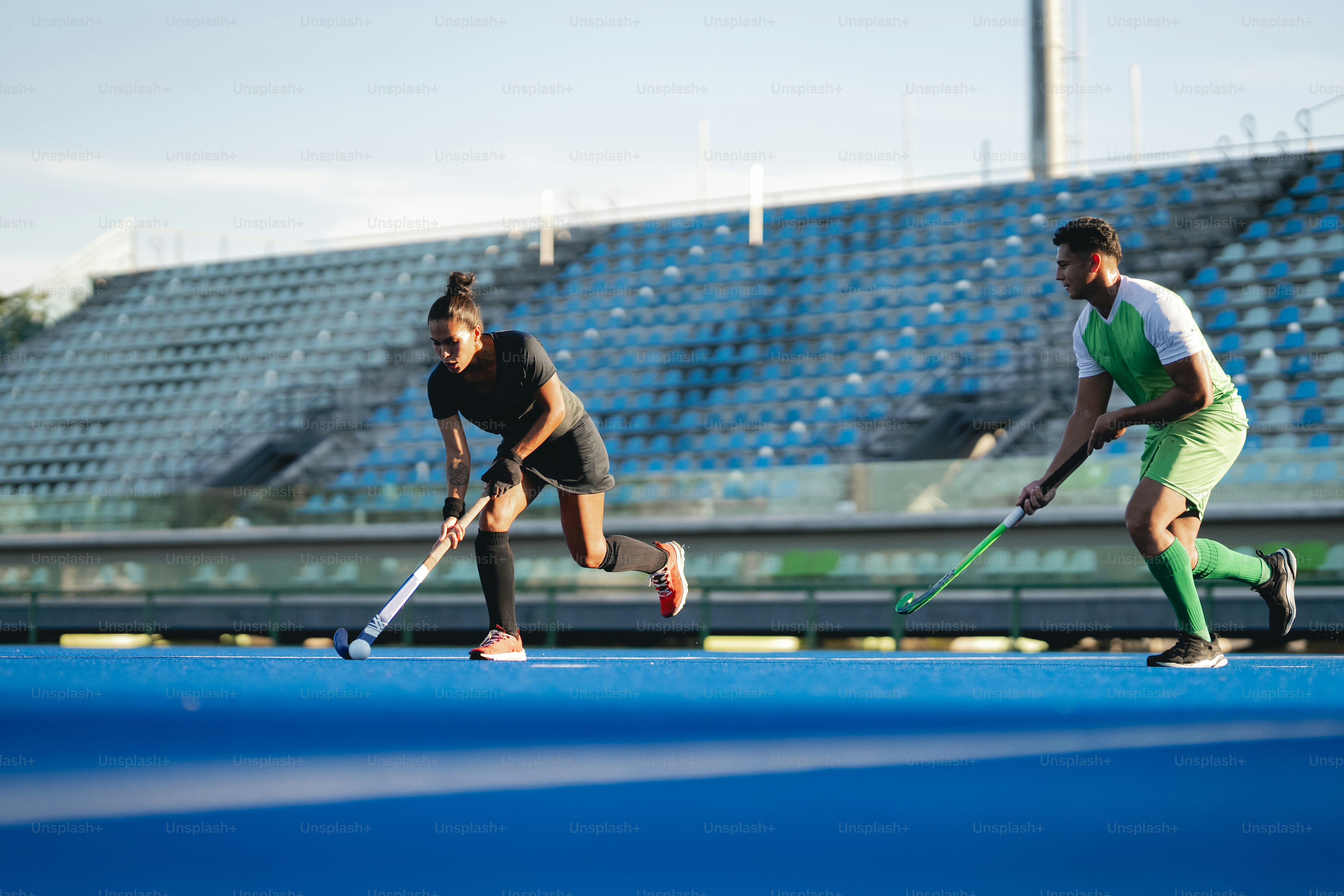 A couple of people playing a game of field hockey