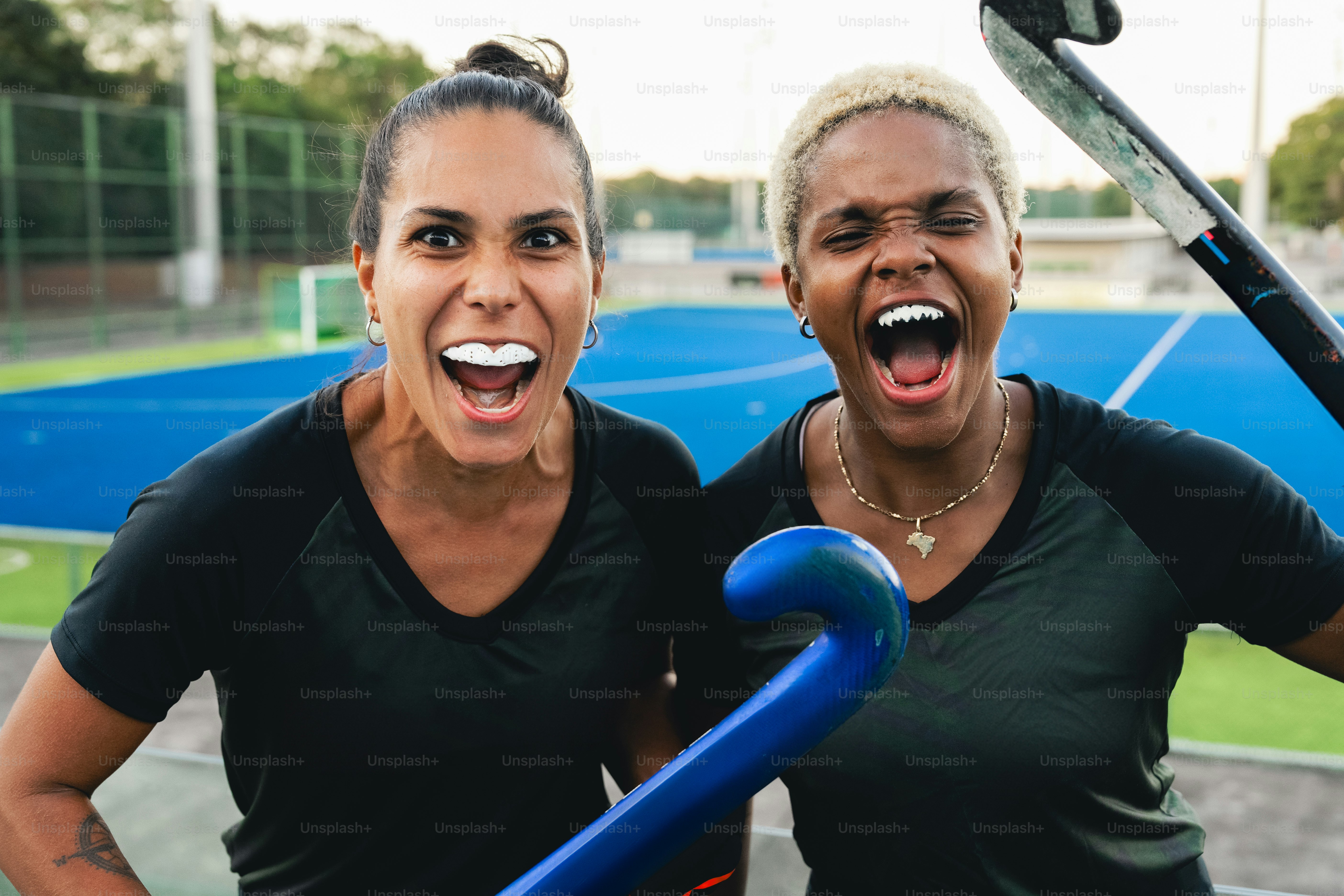 Deux femmes debout l’une à côté de l’autre sur un court de tennis