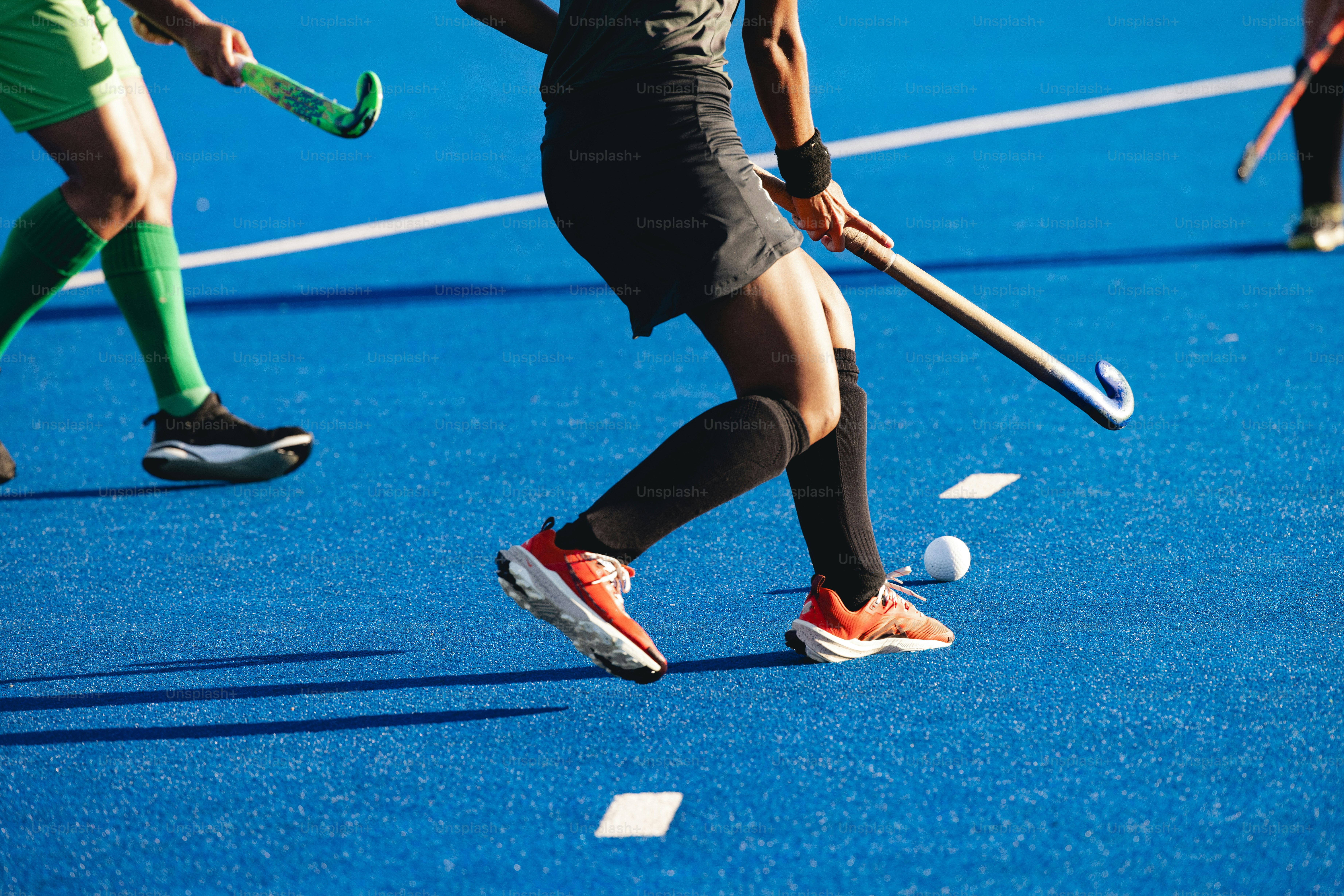 A group of people playing a game of field hockey