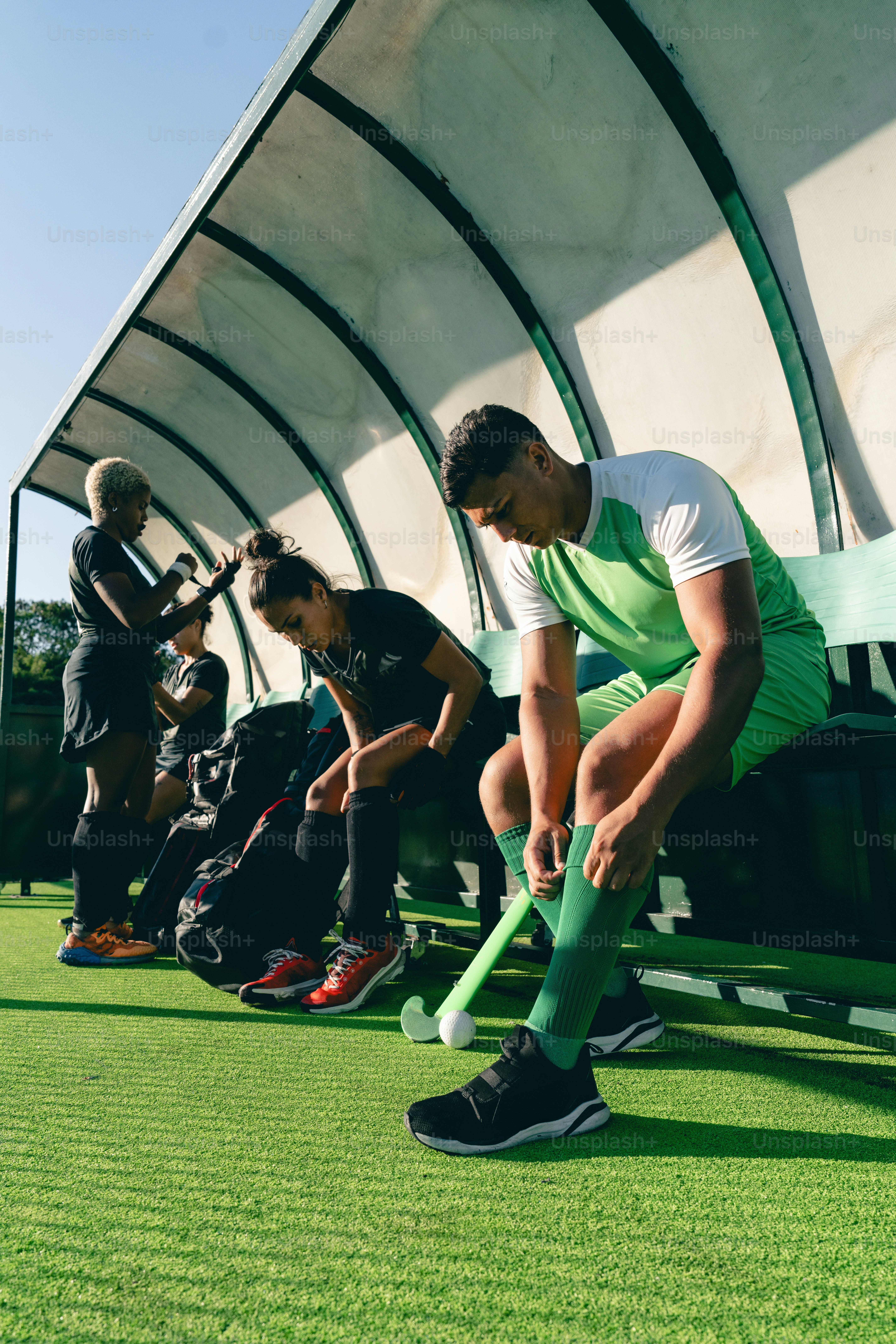 Un groupe d’hommes assis au sommet d’un champ vert