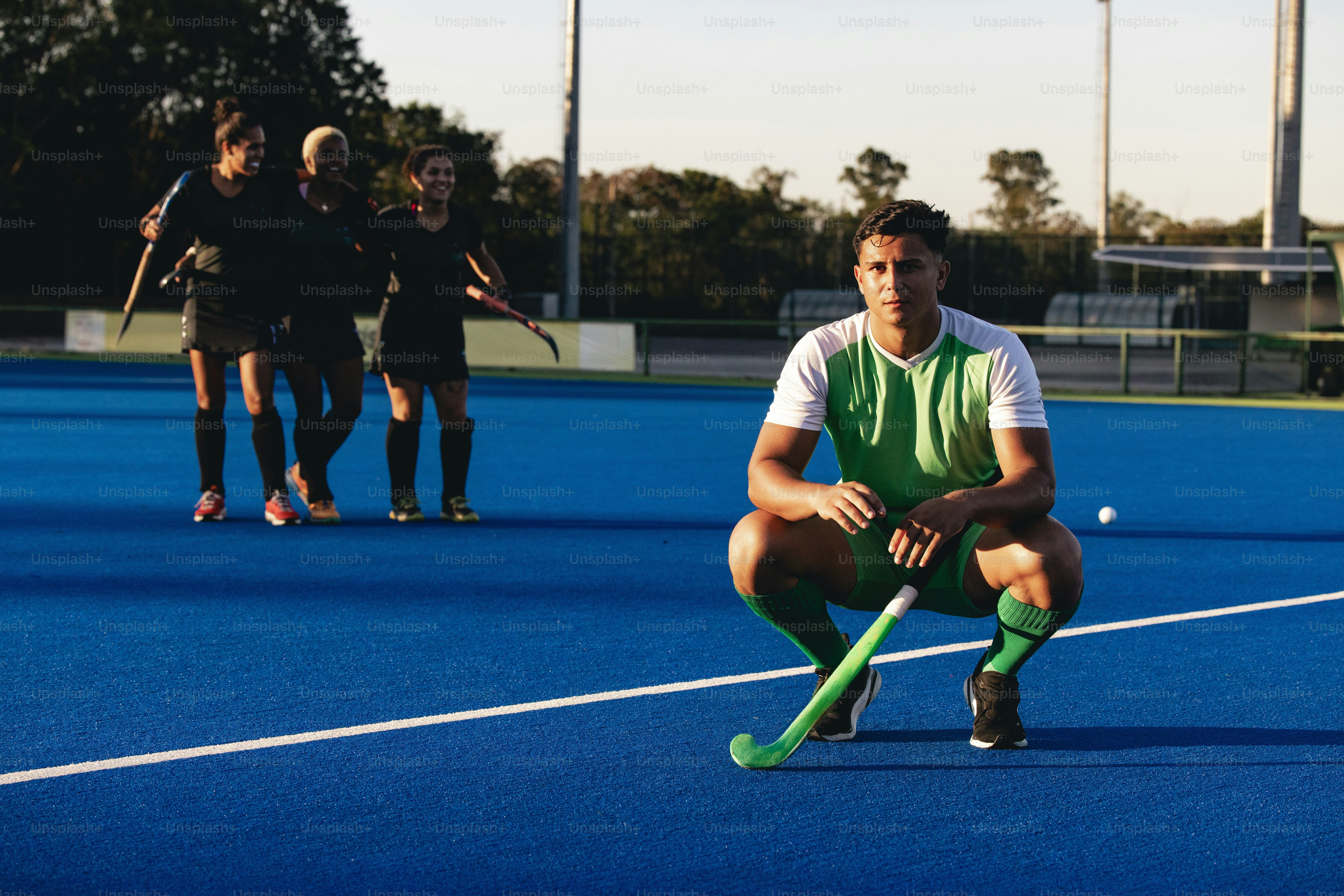 A man kneeling down on top of a blue field