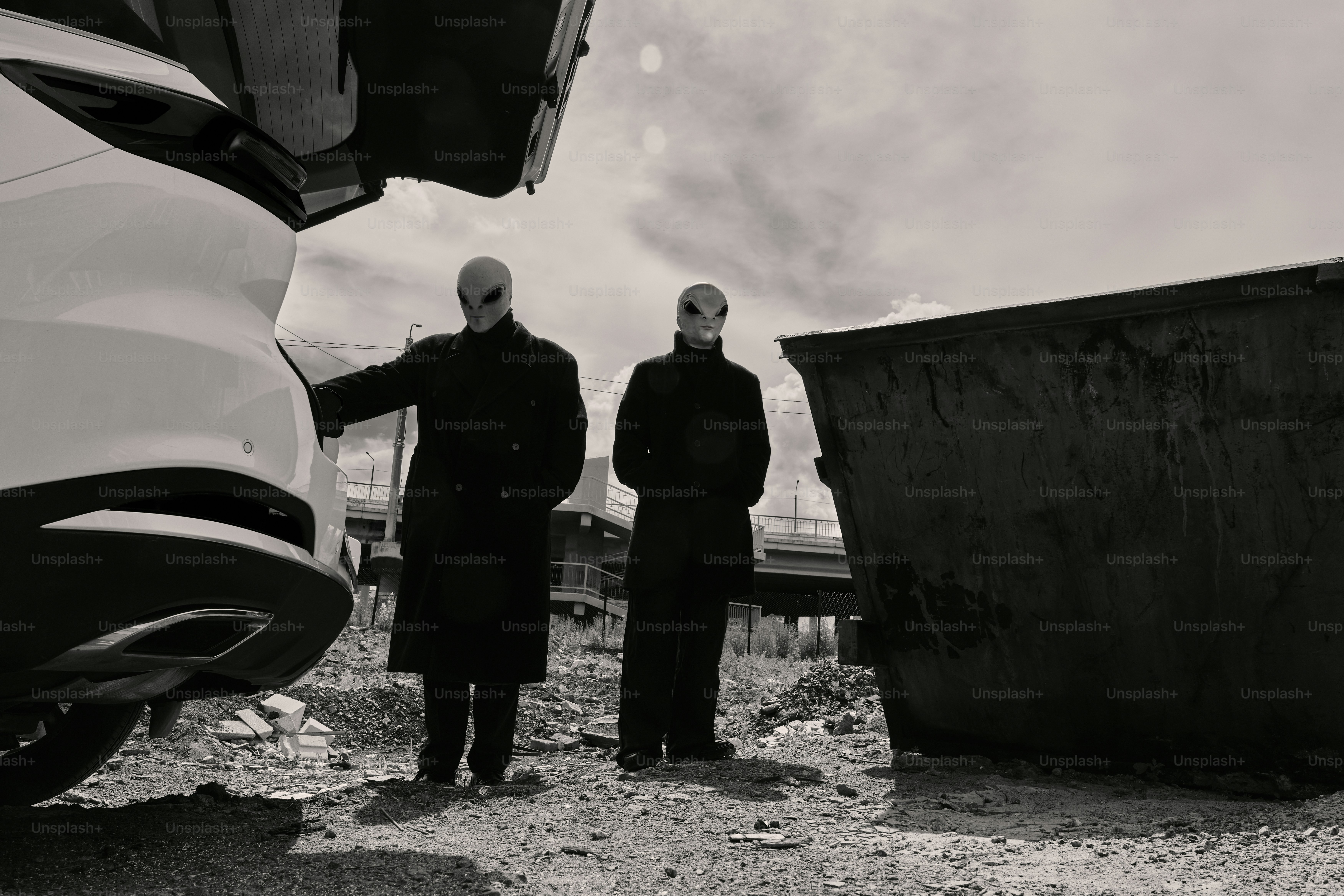 A couple of men standing next to a parked car