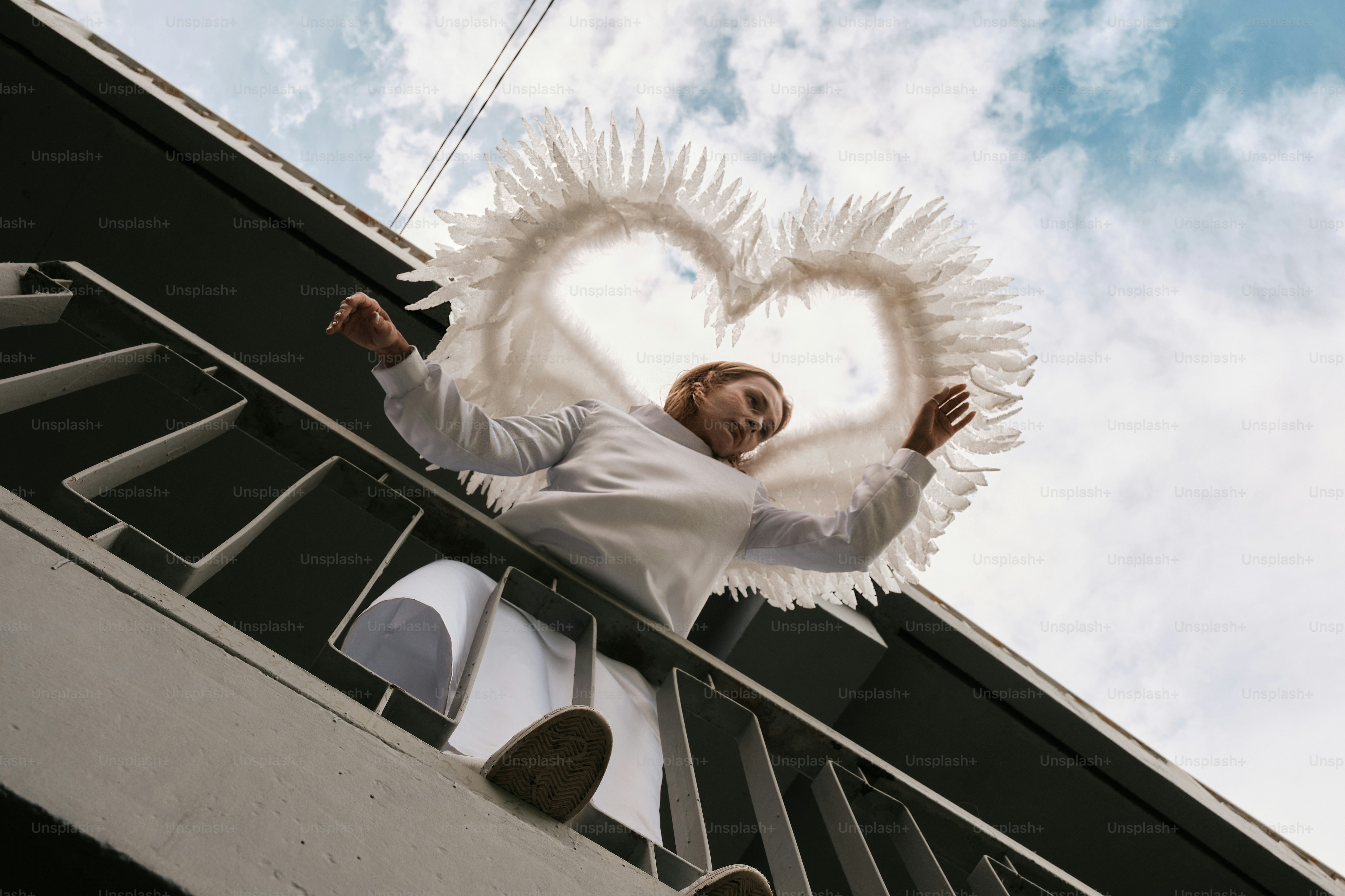 Um homem em cima de uma varanda ao lado de um prédio