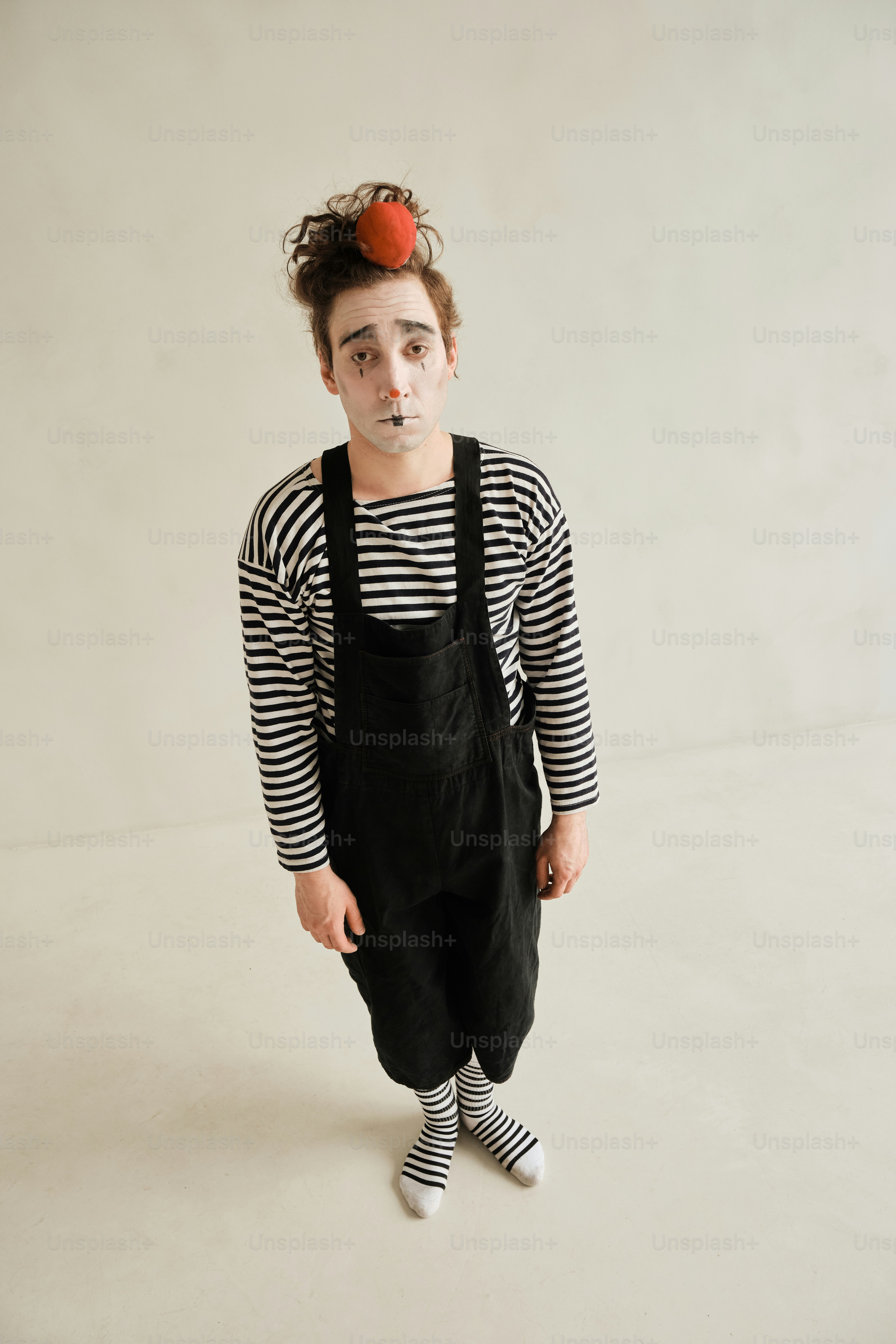 Una niña con nariz de payaso y mono negro