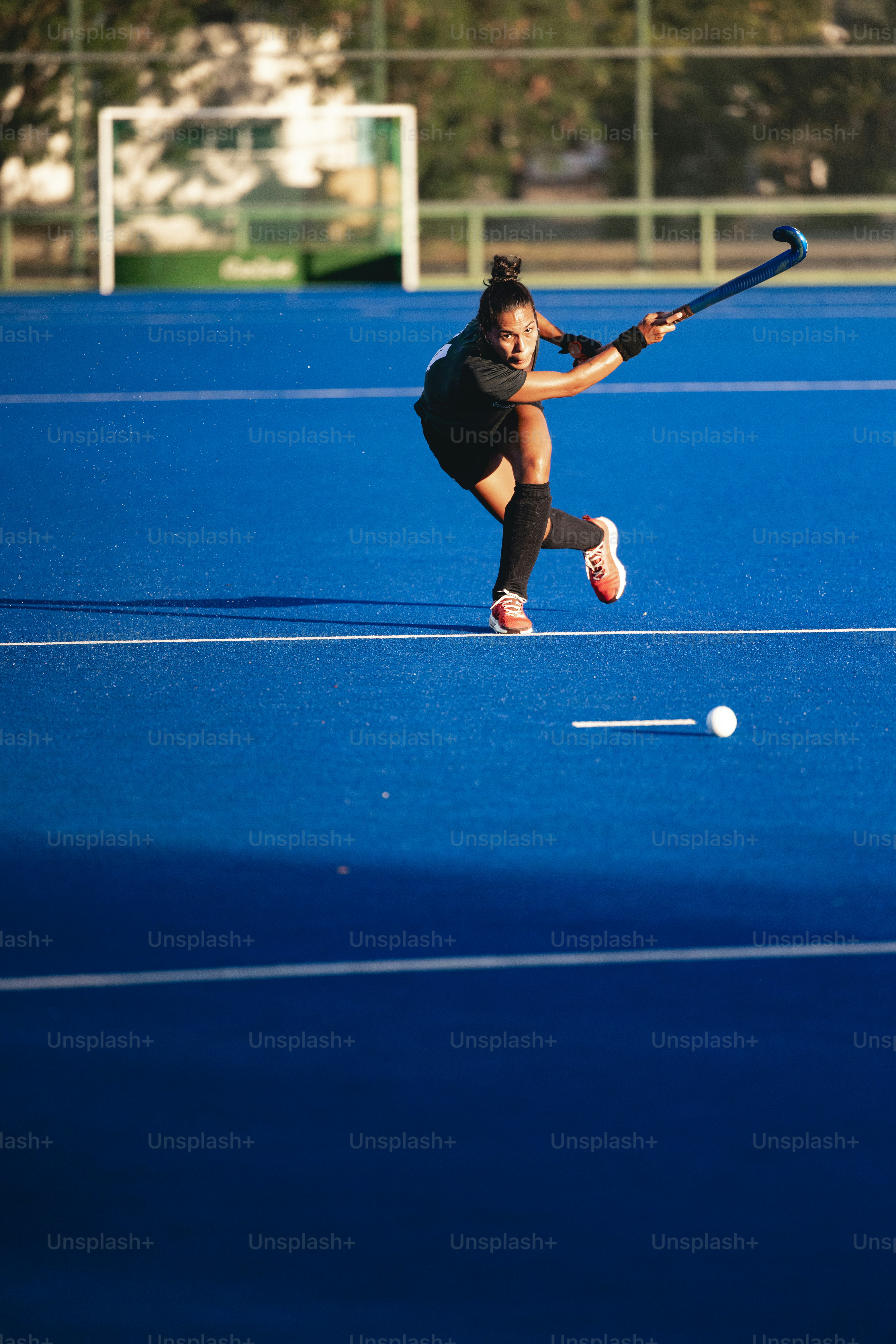 A woman is playing tennis on a blue court