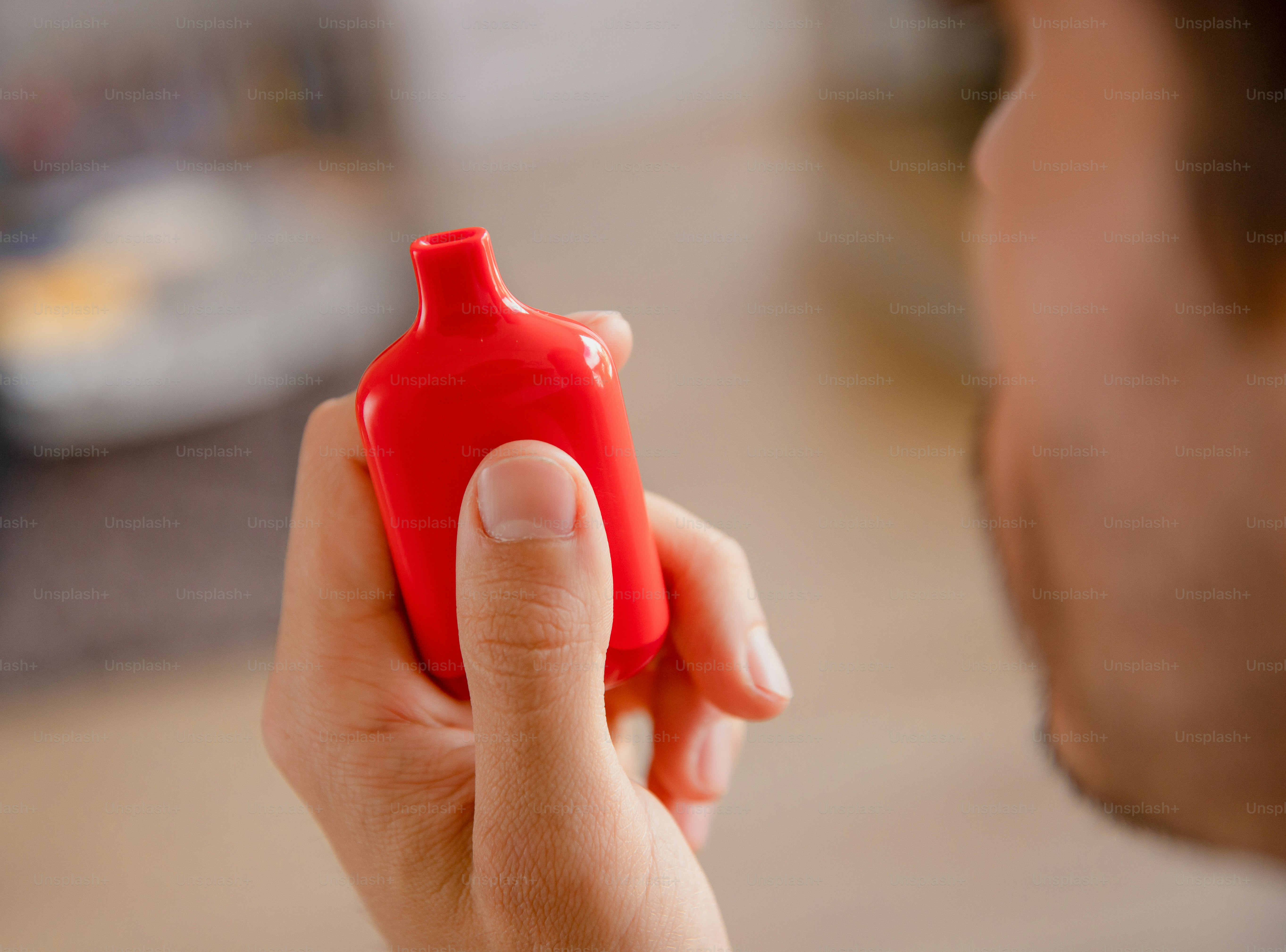 A man holding a small red object in his hand
