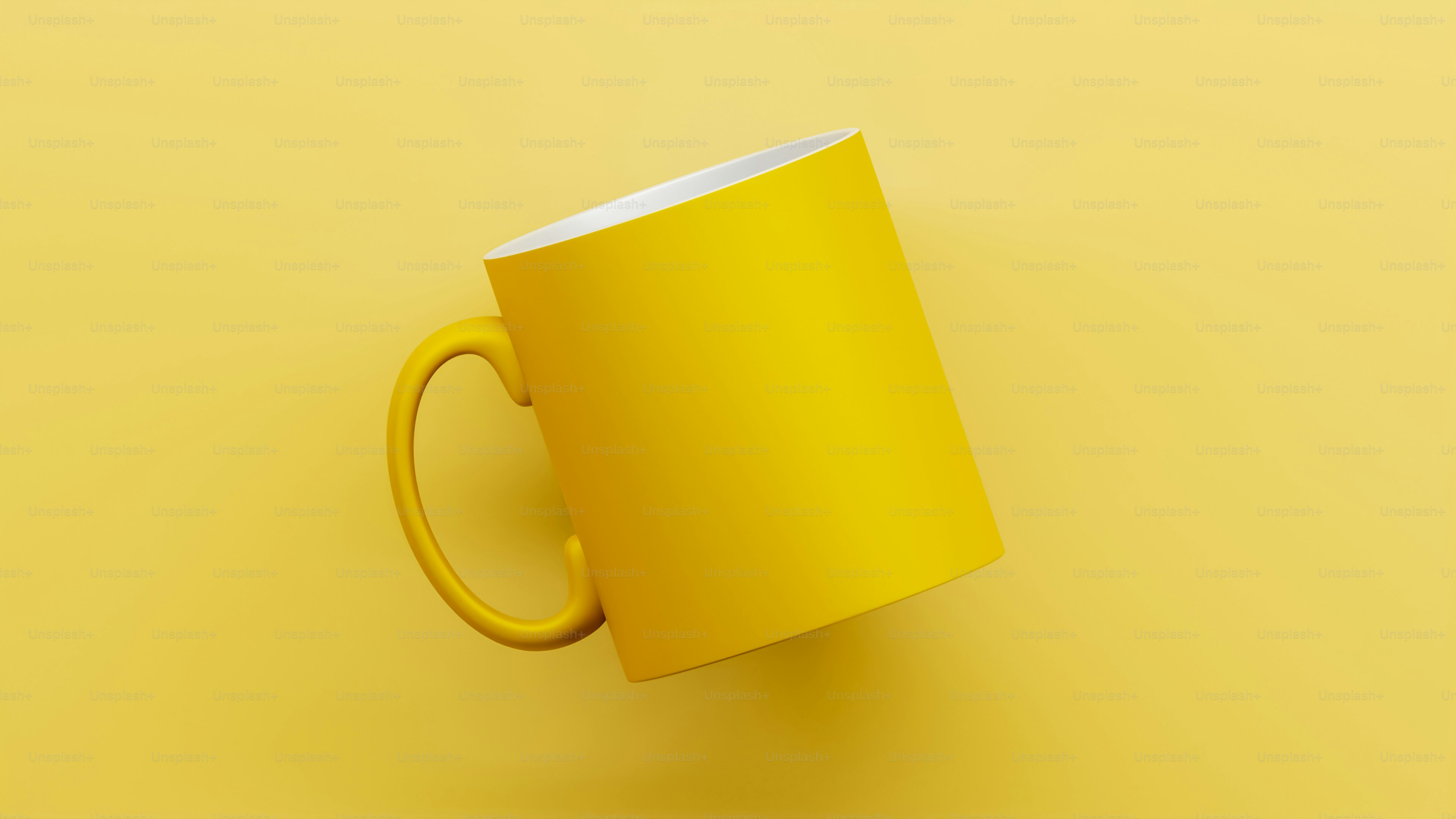 A yellow coffee cup sitting on top of a yellow table
