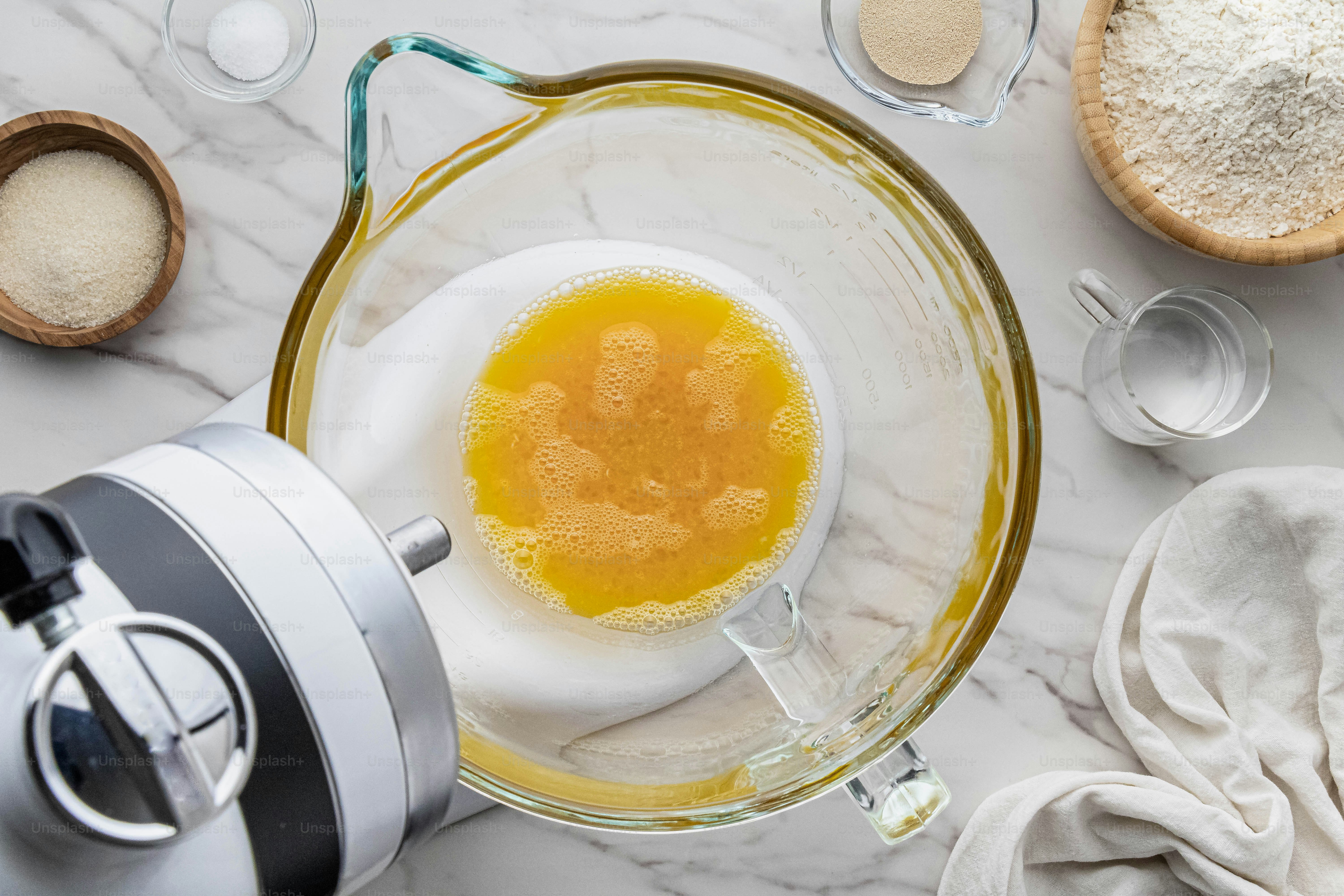 A blender with an egg in it next to other ingredients