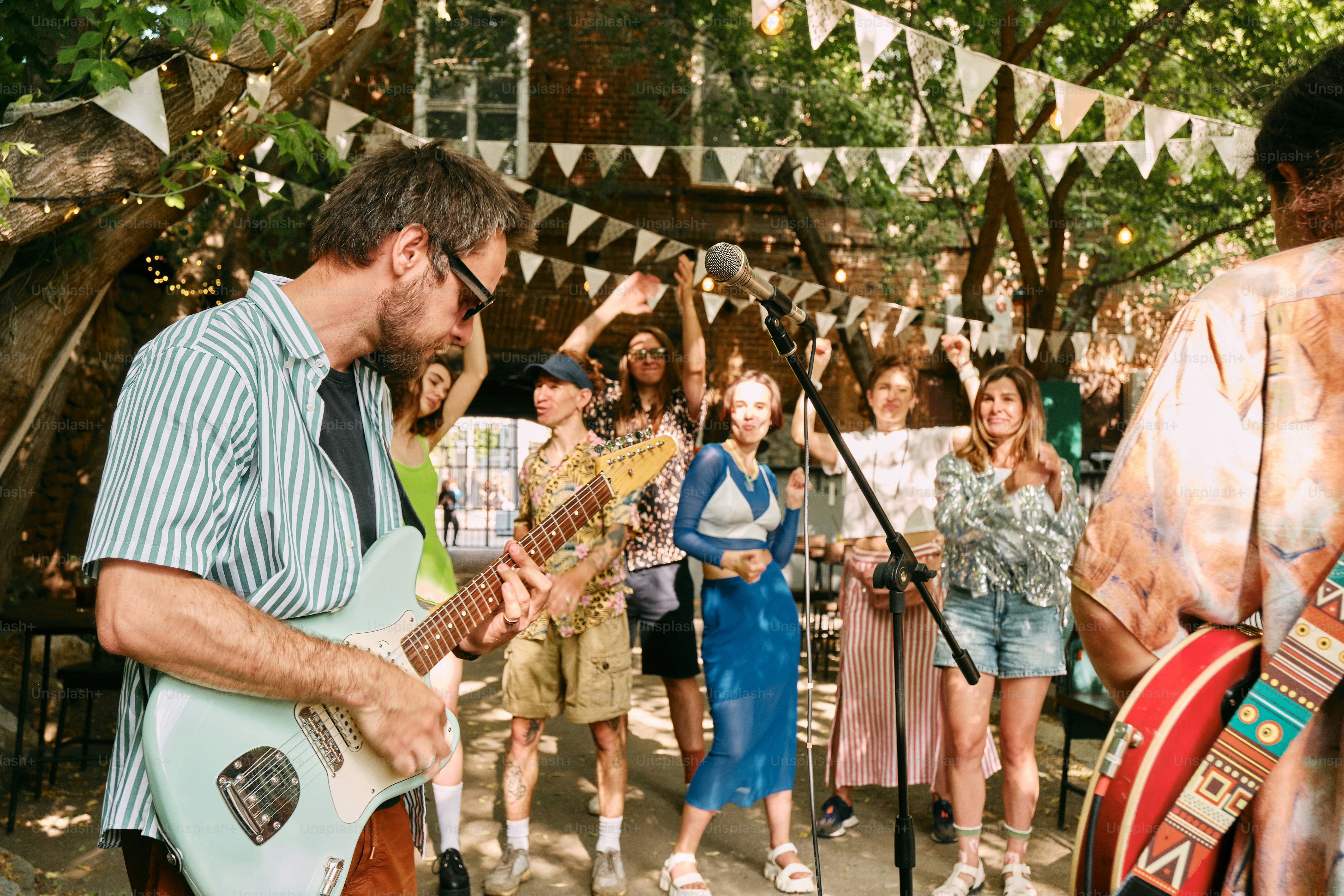 A man playing a guitar in front of a group of people
