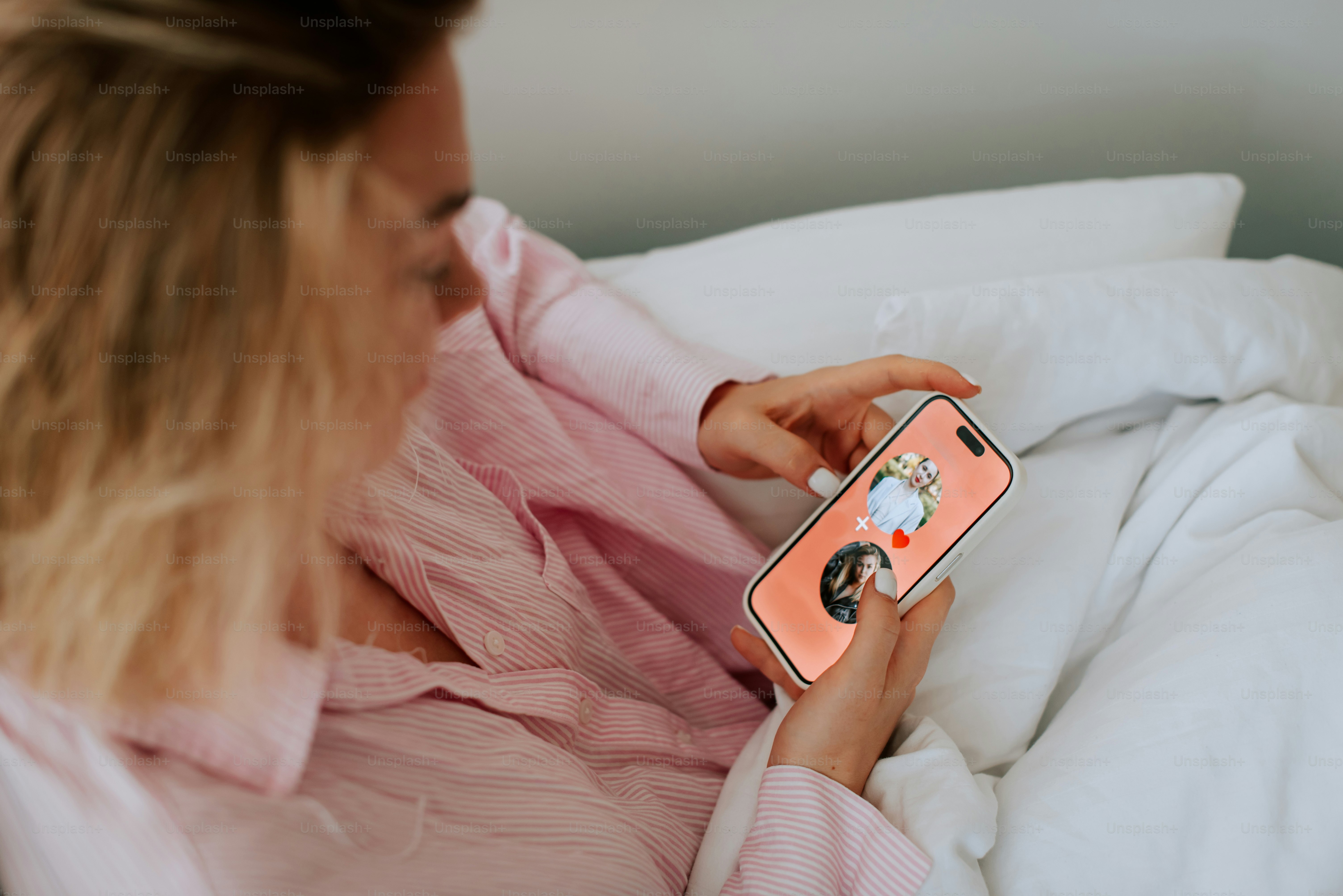 A woman laying in bed with a cell phone in her hand- how to increase focus