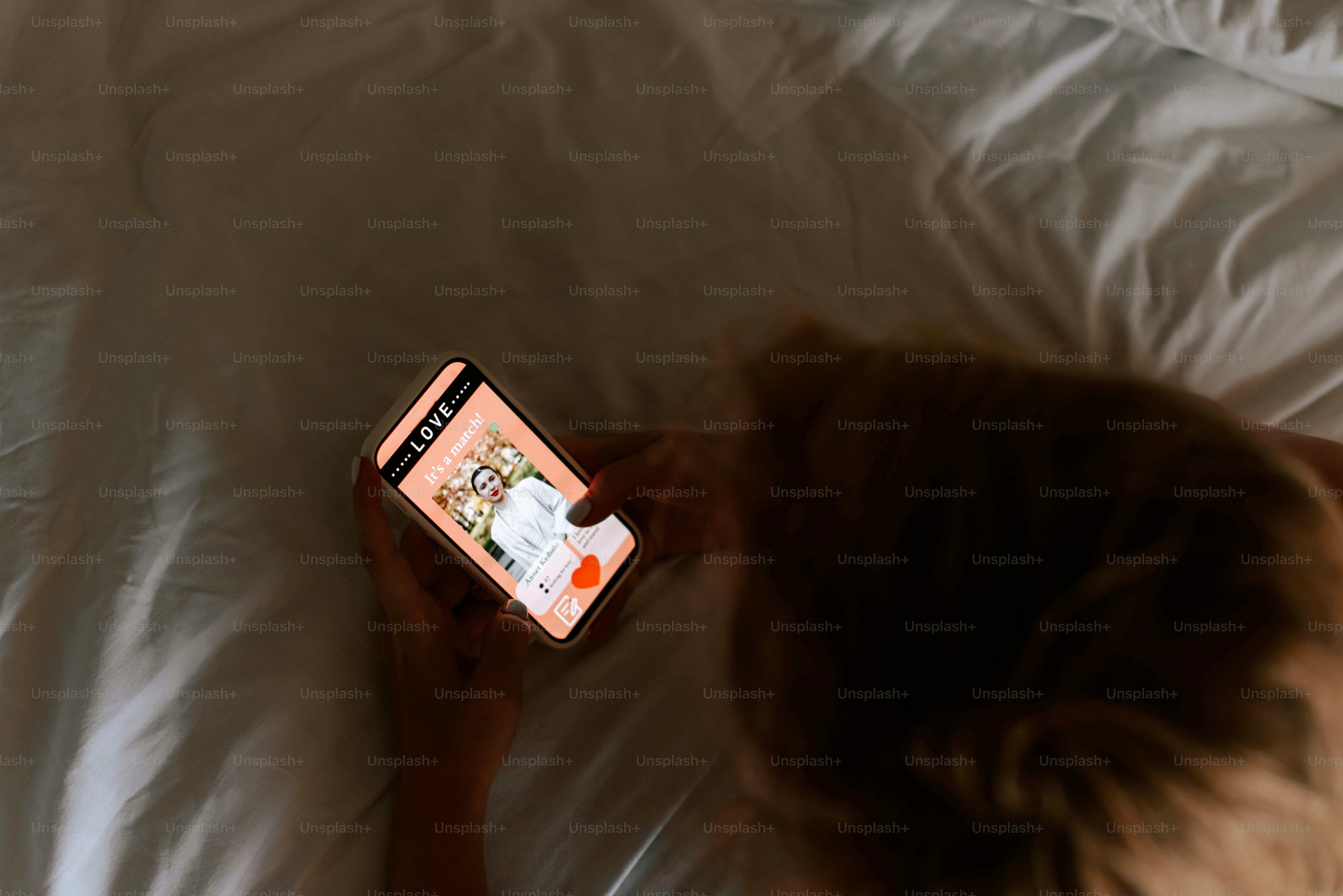 A person laying in bed with a cell phone