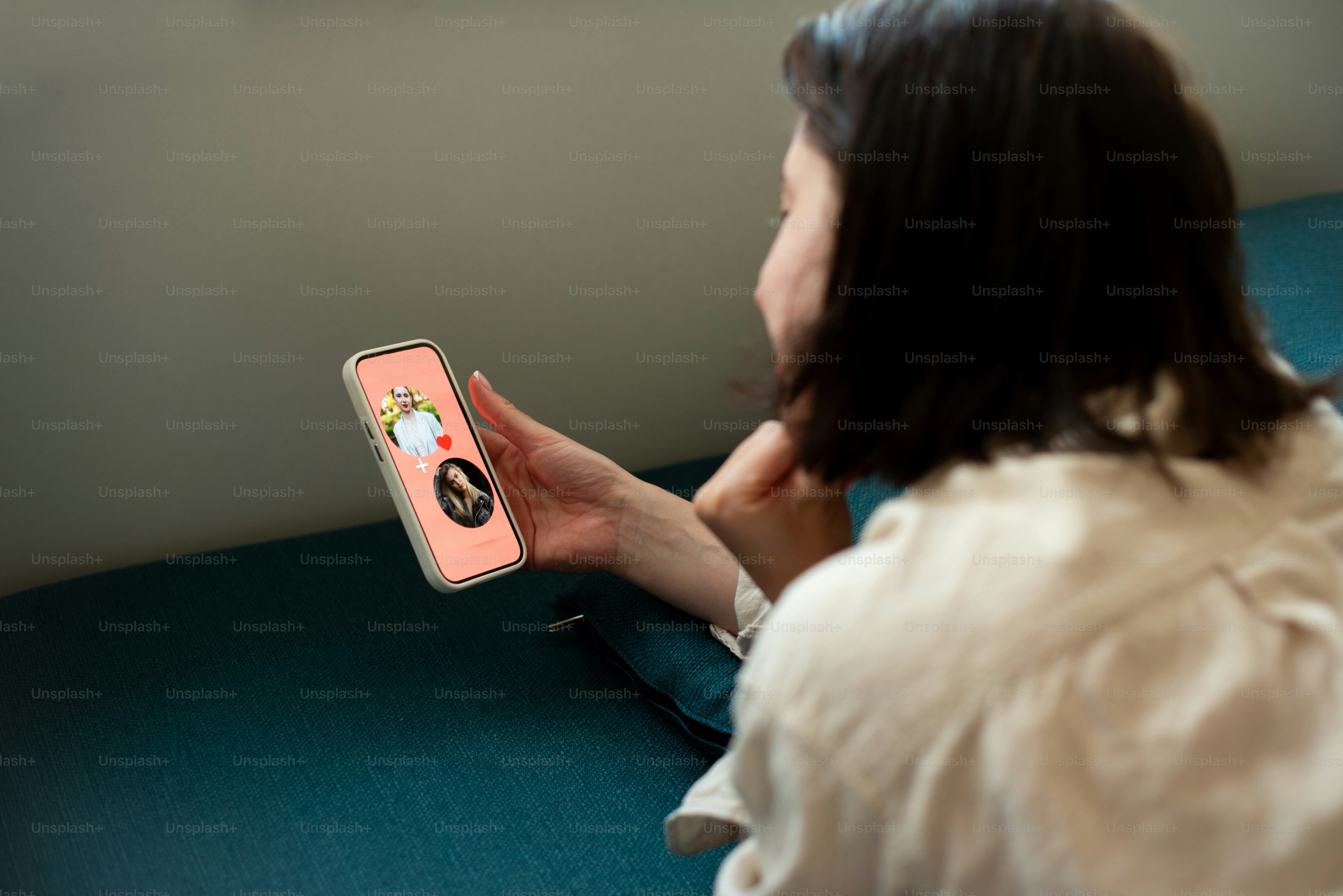 A woman sitting on a couch holding a cell phone