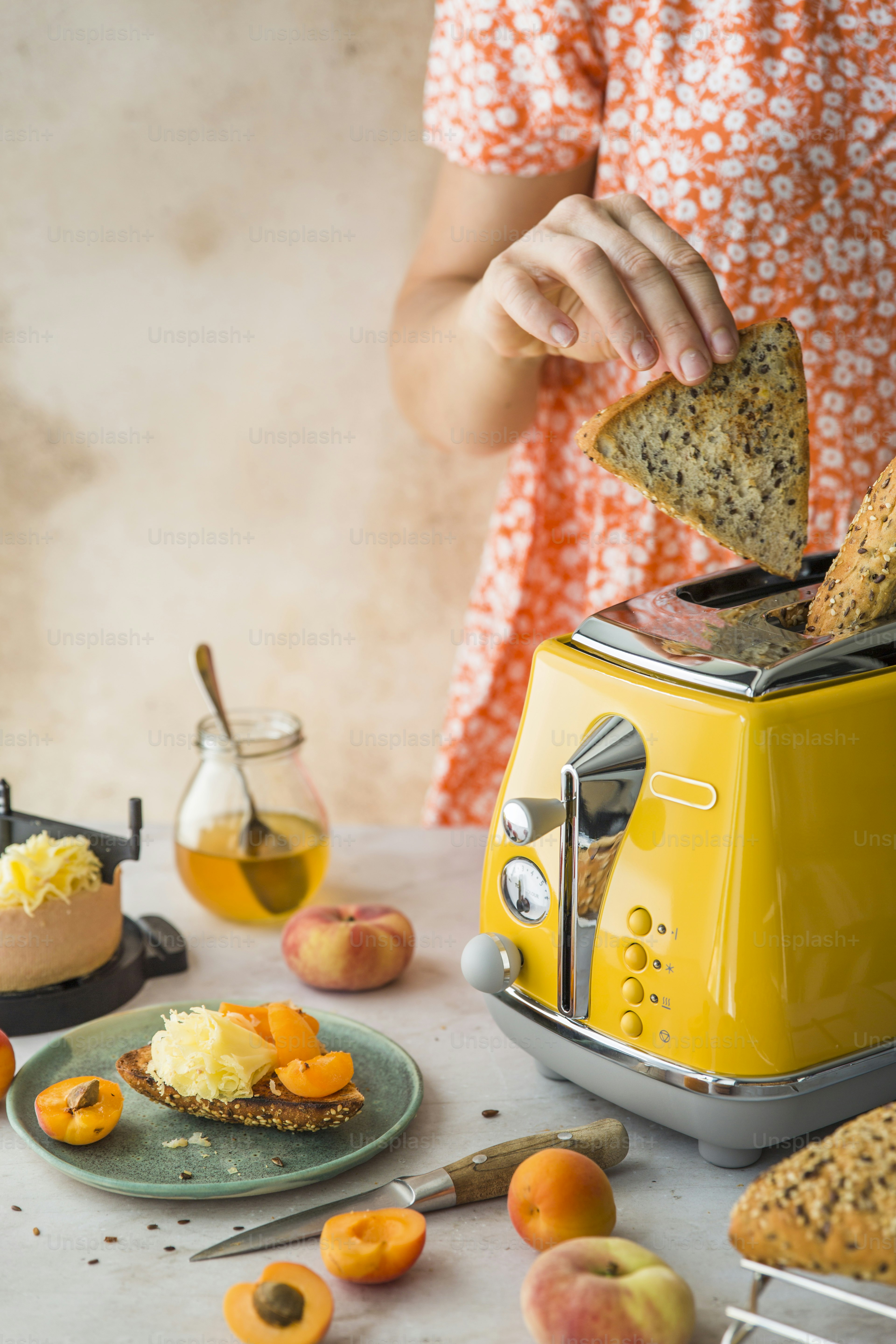 A woman is making a toaster with fruit on it