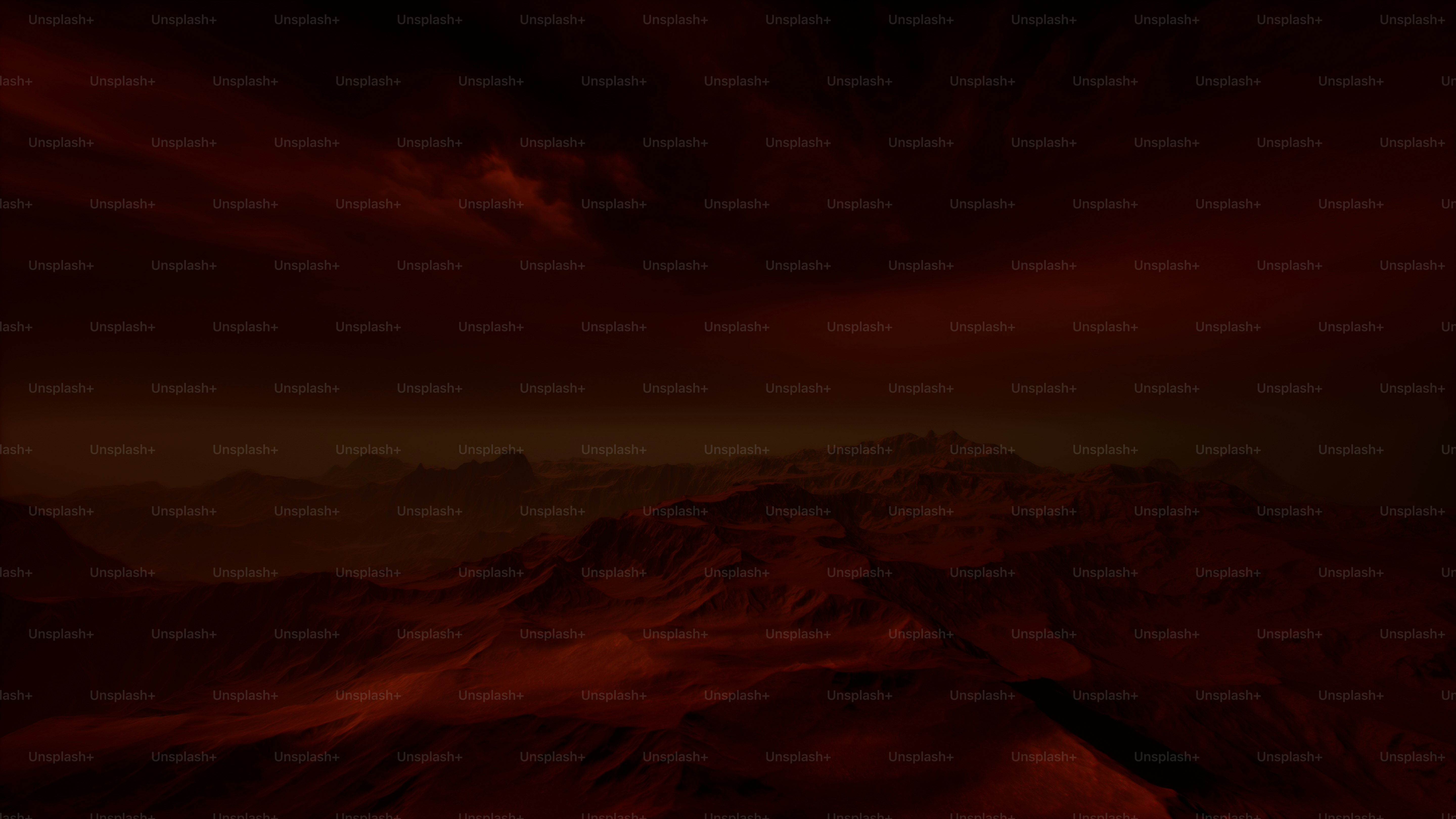 A view of a mountain with a red sky in the background