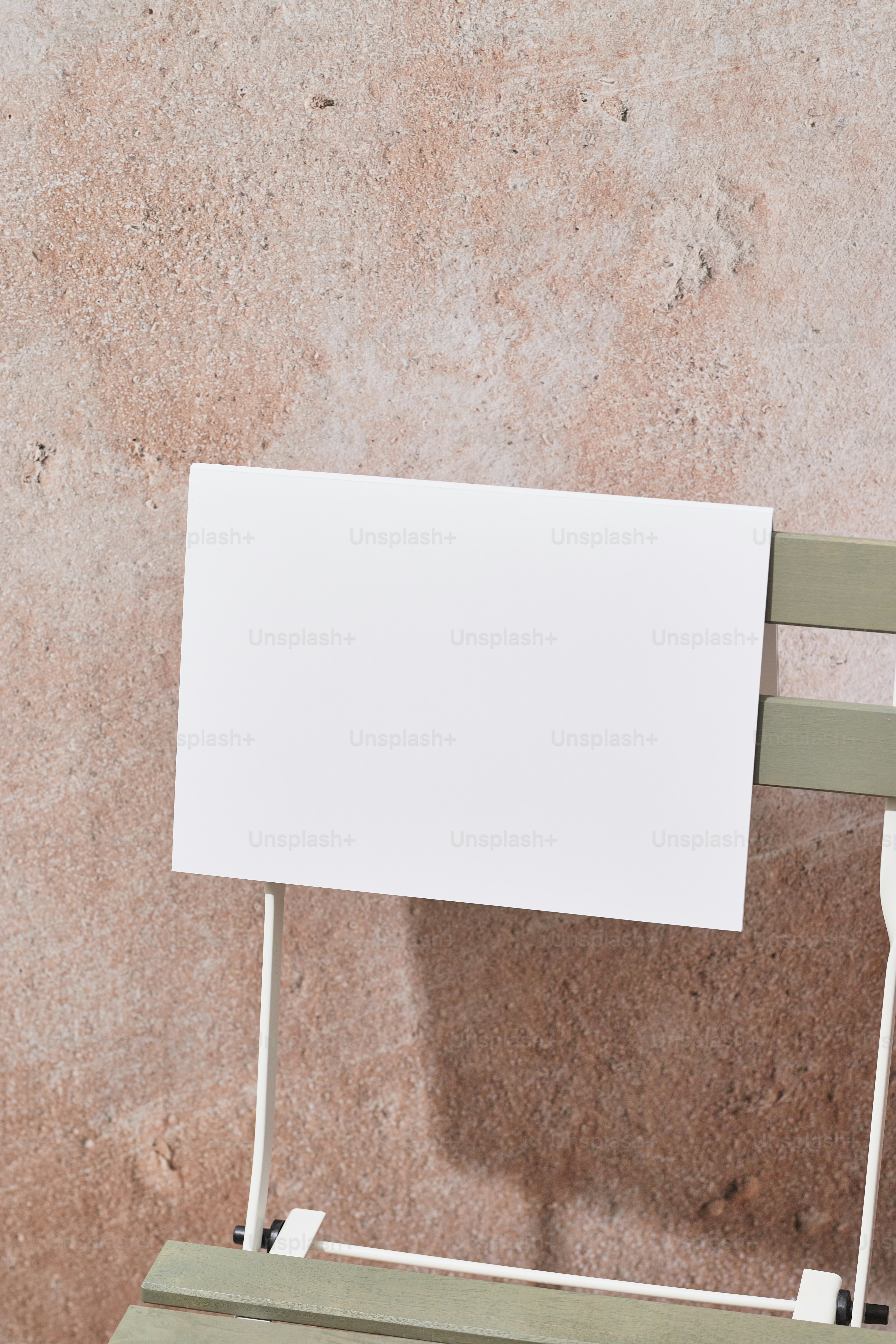 A white sign sitting on top of a wooden bench