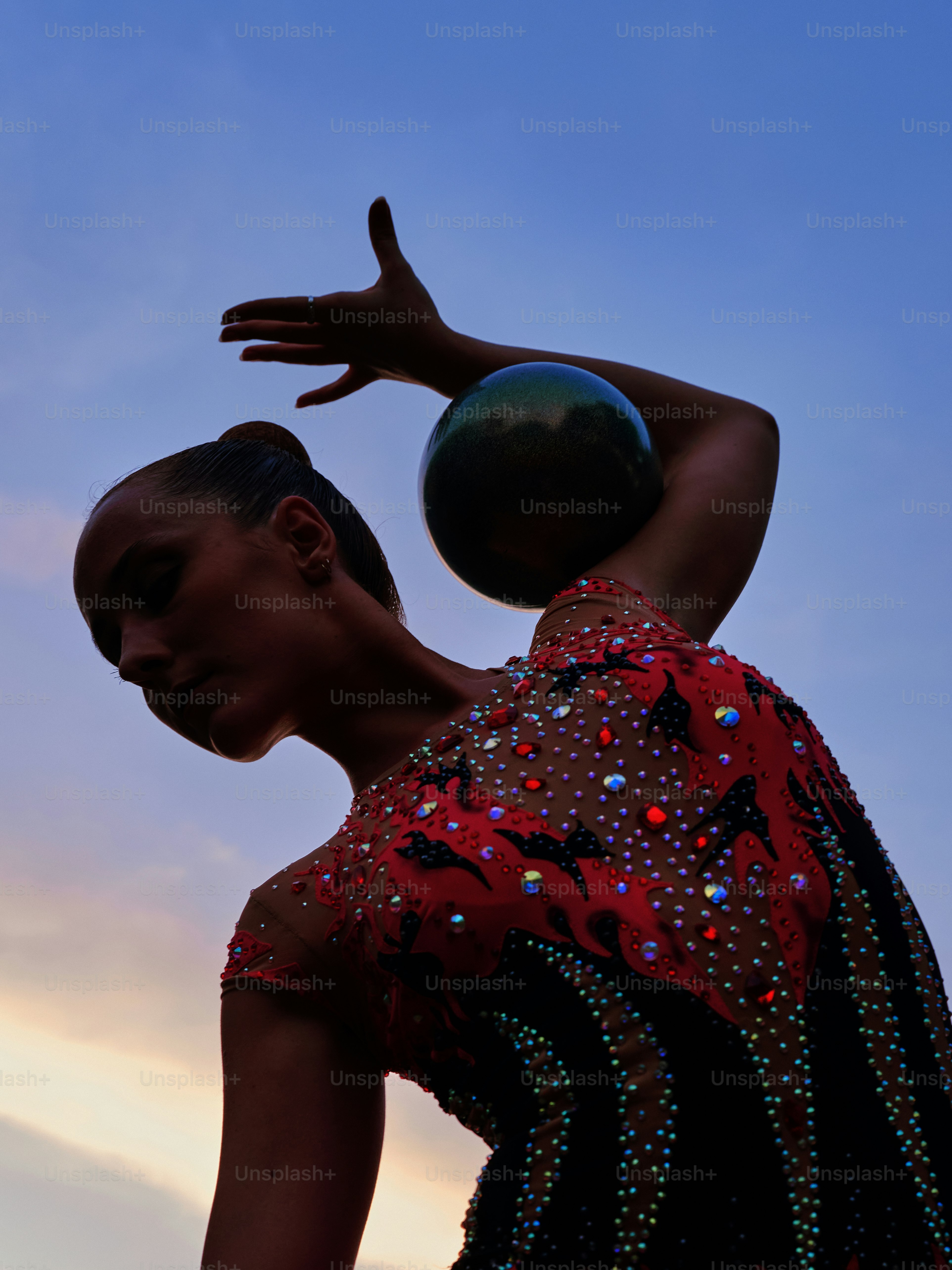 Une femme en robe rouge et noire tenant un ballon