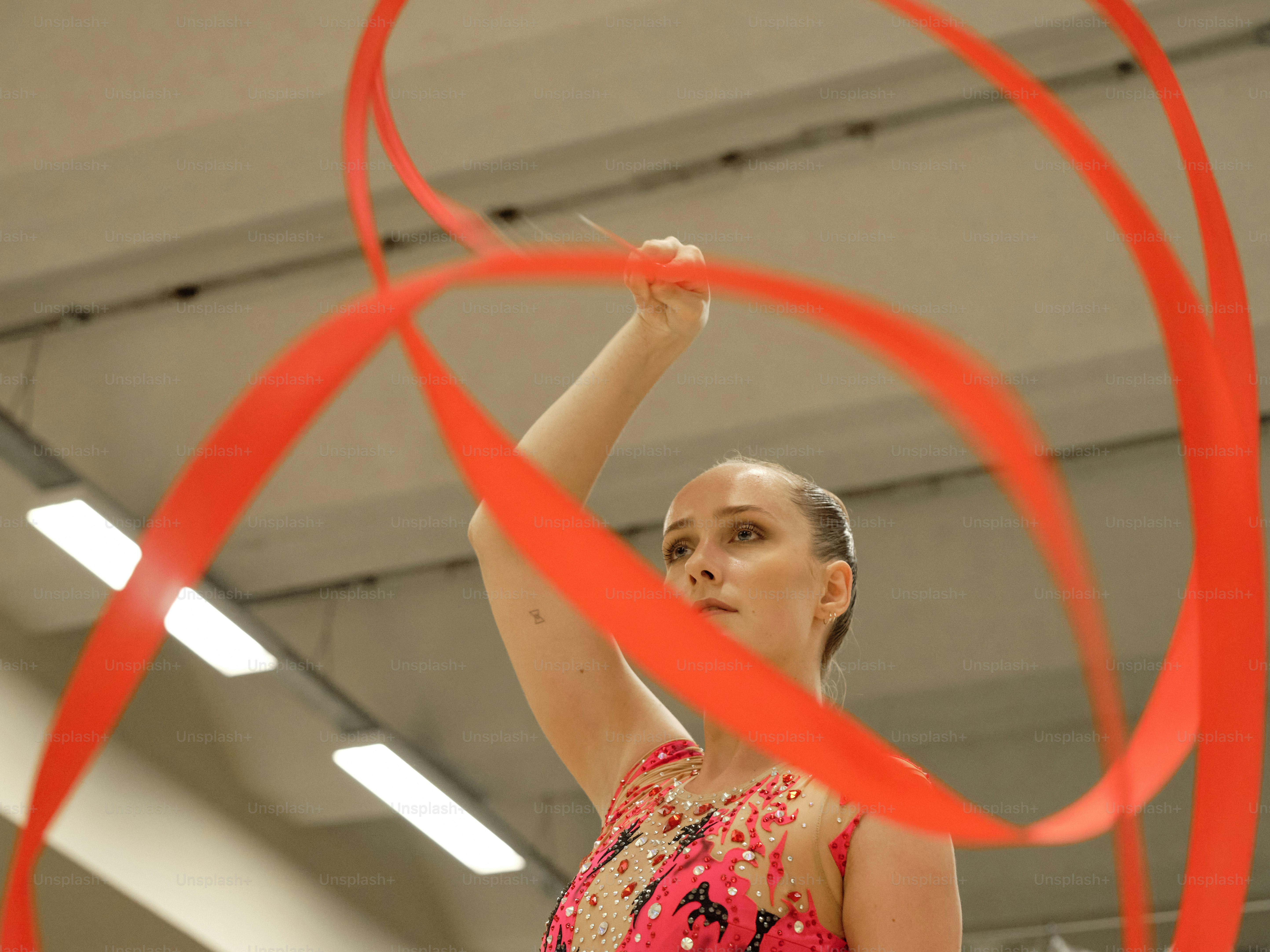 A woman is holding a red ribbon in the air