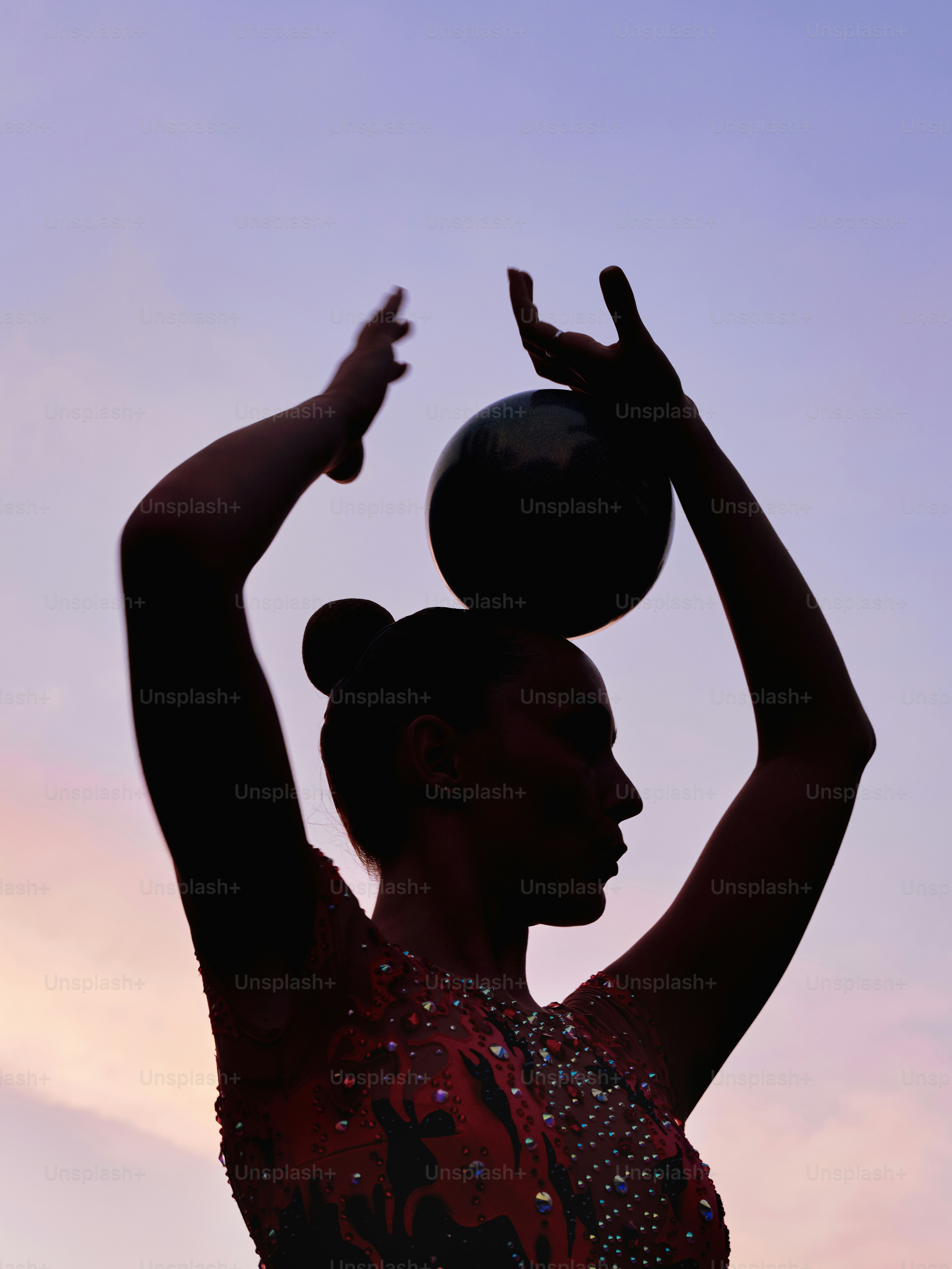 A silhouette of a woman with a ball in her hand