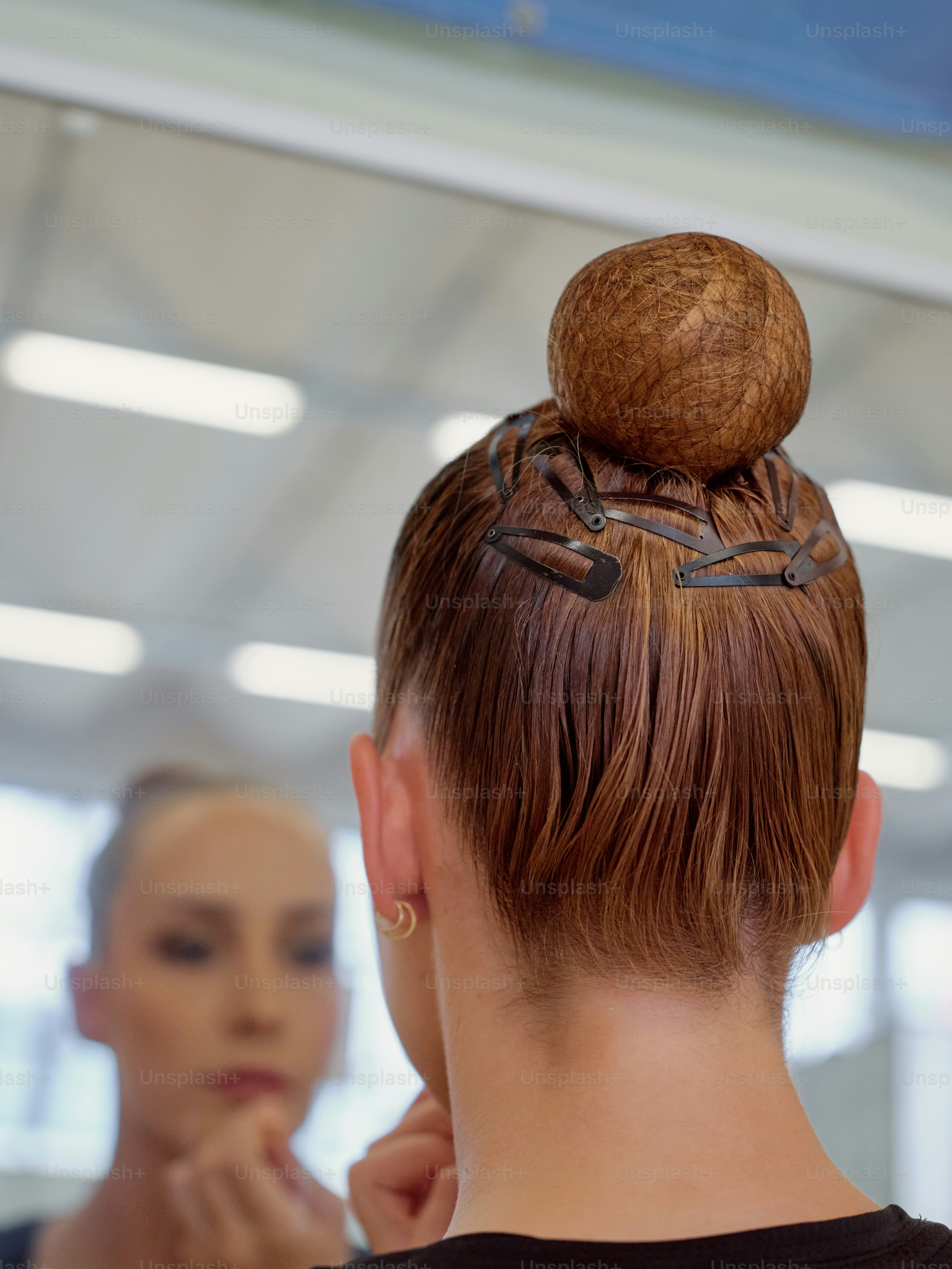 Seorang wanita berbaju hitam sedang melakukan gaya rambut