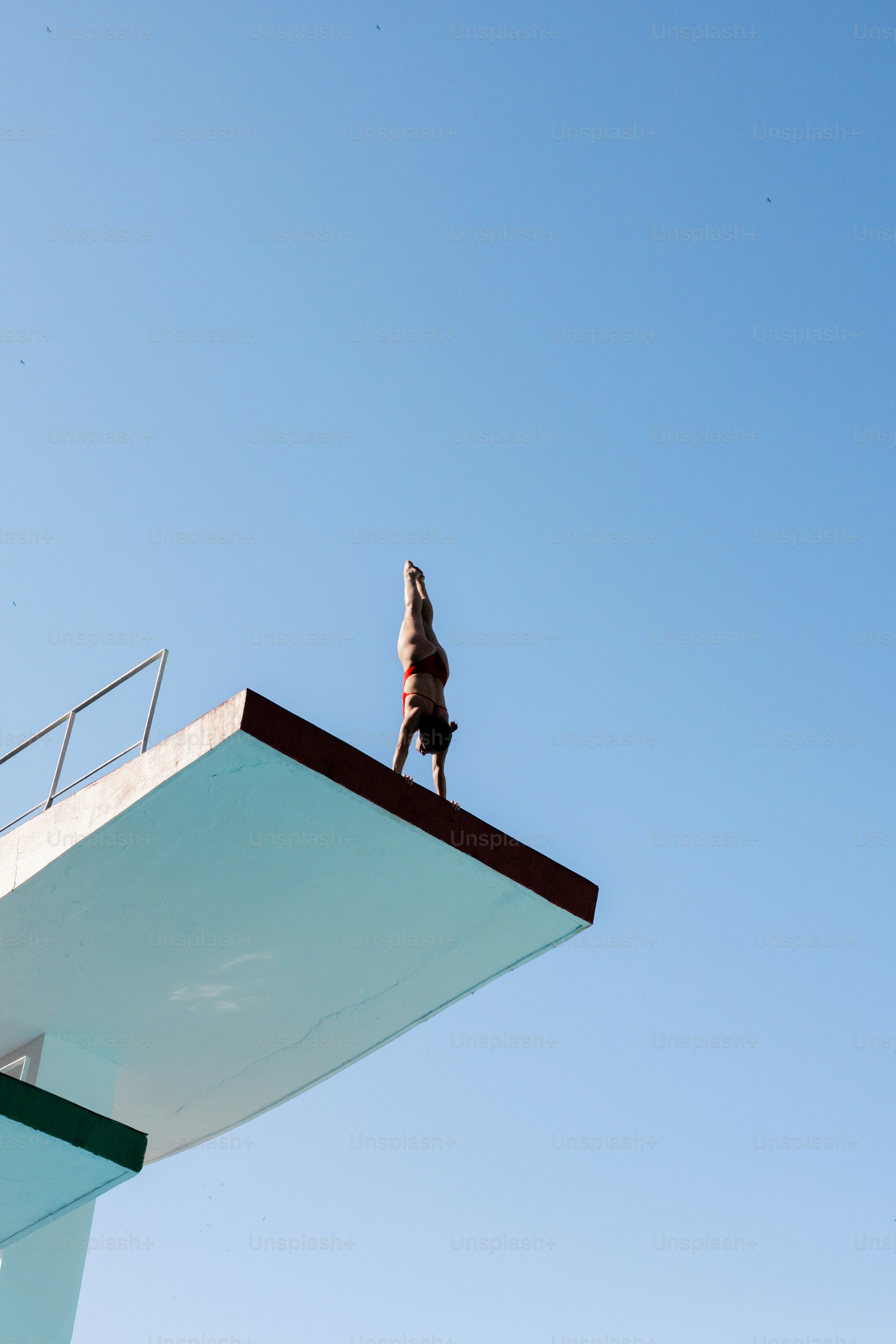A person standing on a ledge above a building