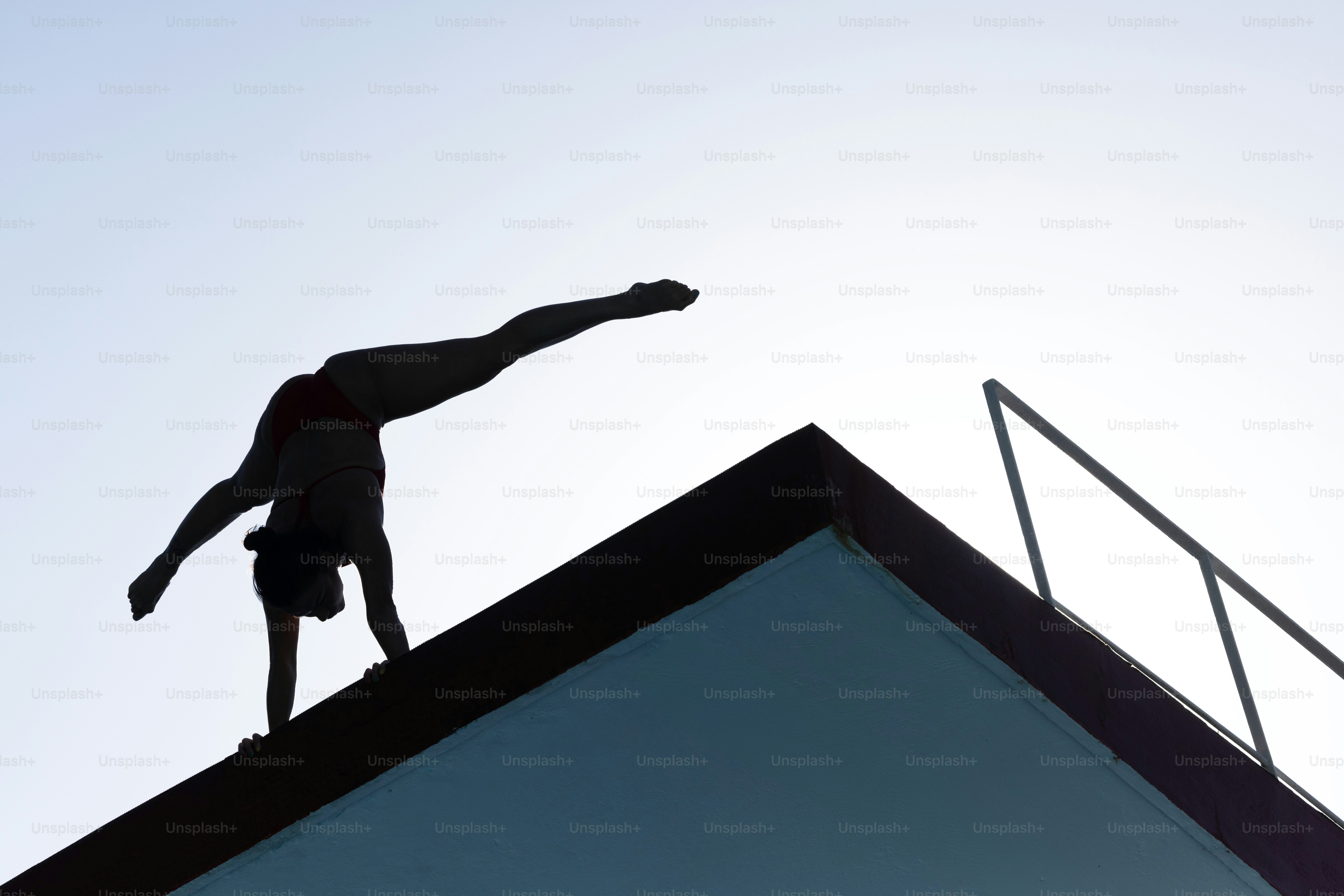 A silhouette of a person on top of a building