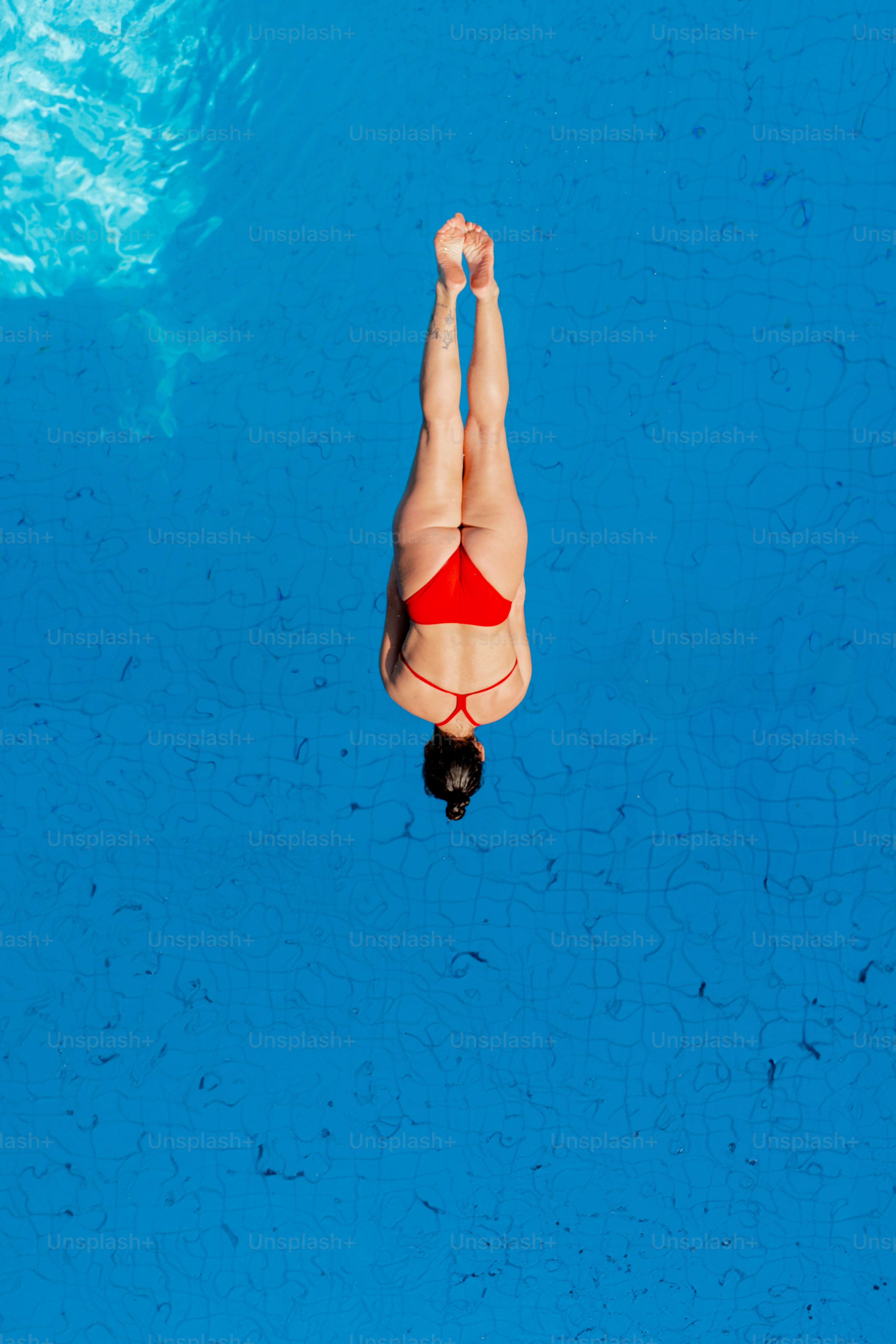A woman in a red bikini swimming in a pool