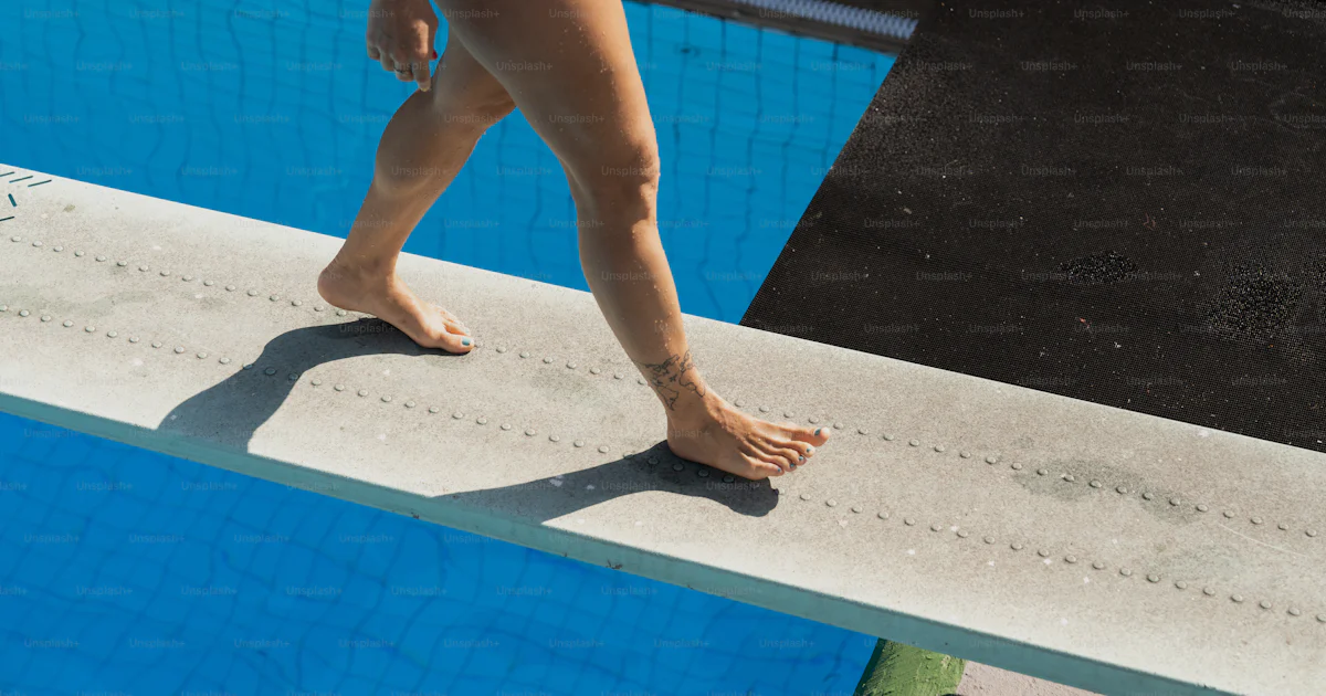 Walking In Pool A woman in a red swimsuit walking along a swimming pool photo – Diving ...