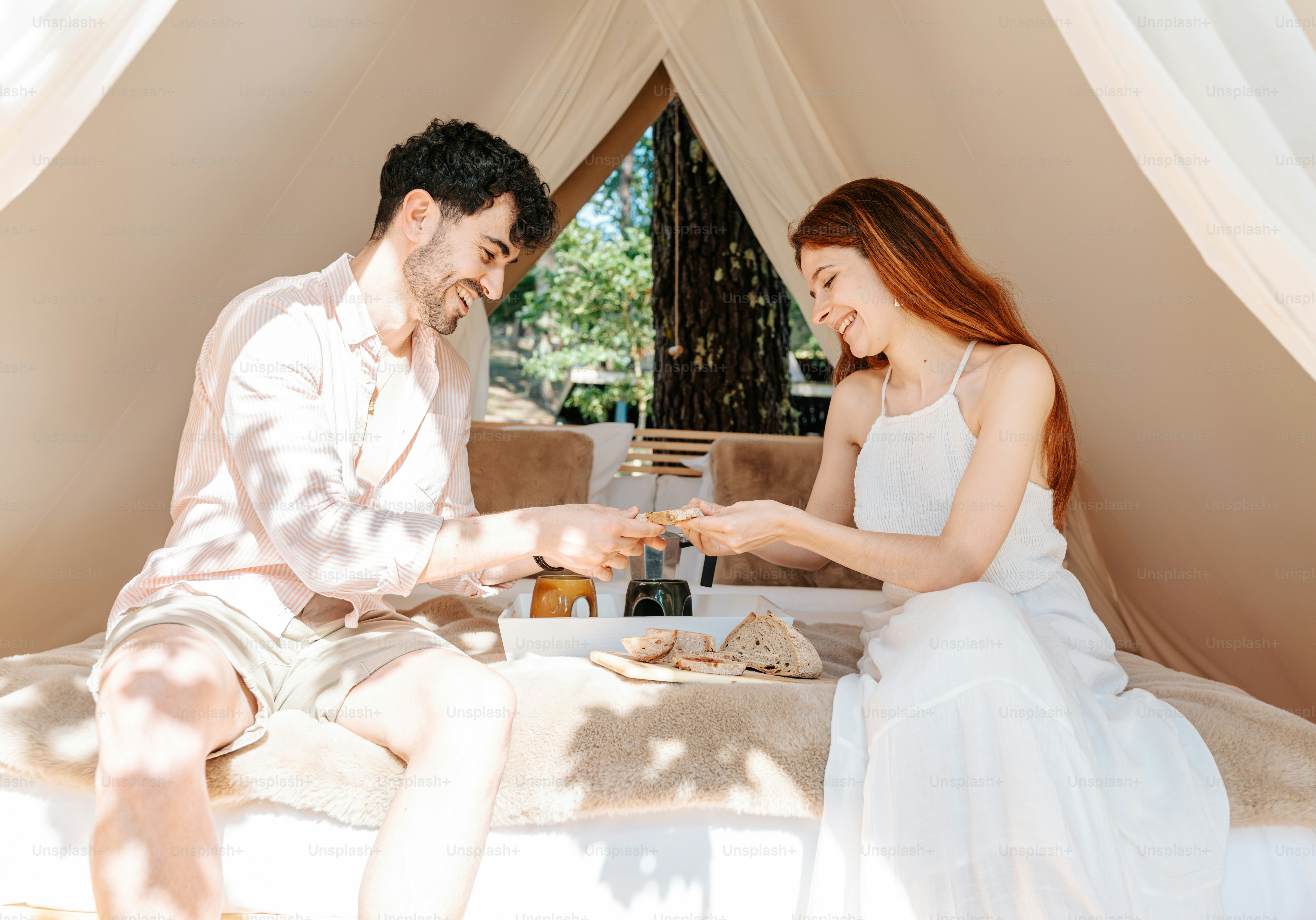 A man and a woman are sitting in a tent