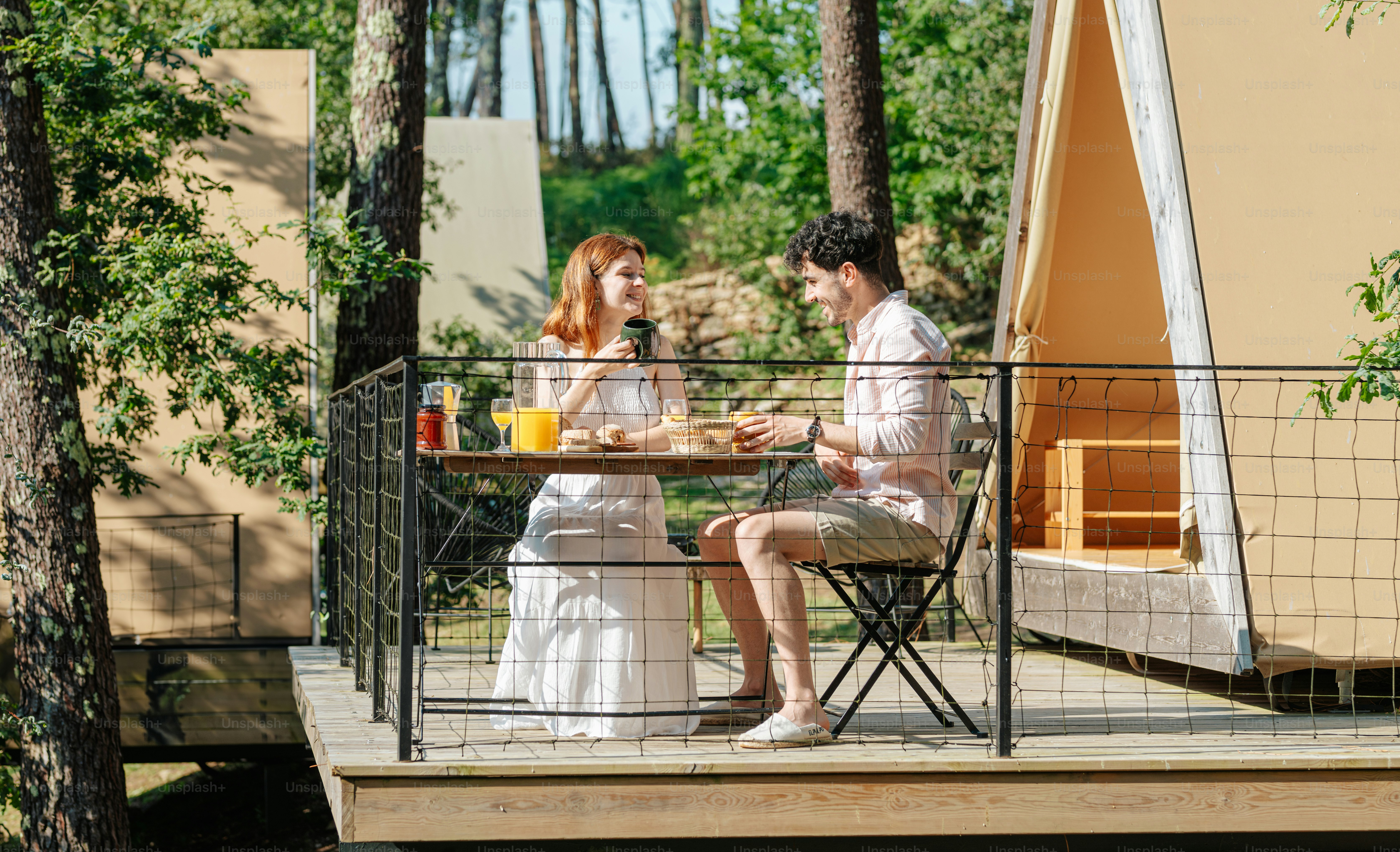 A man and a woman sitting at a table on a deck