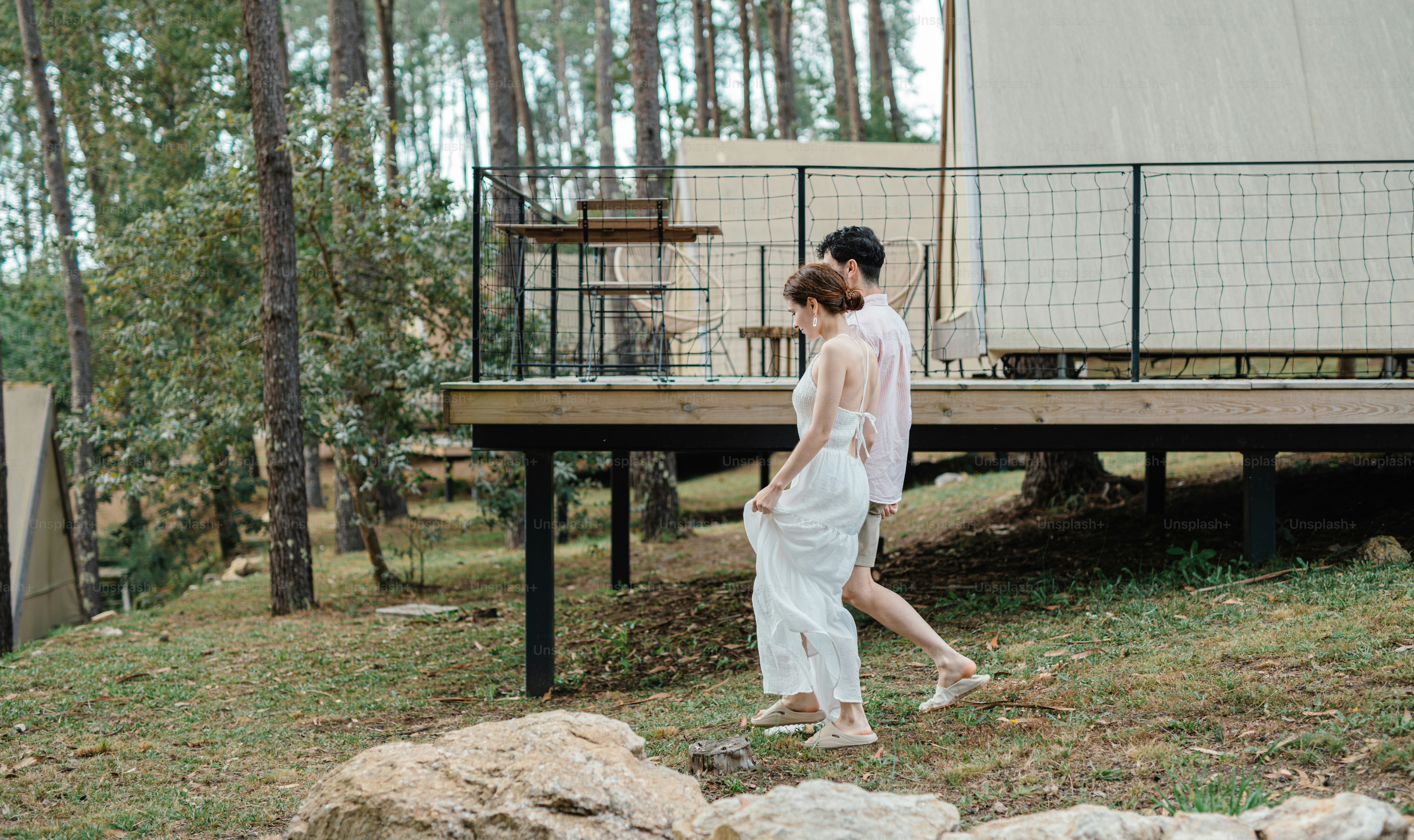 A woman in a white dress walking in front of a house