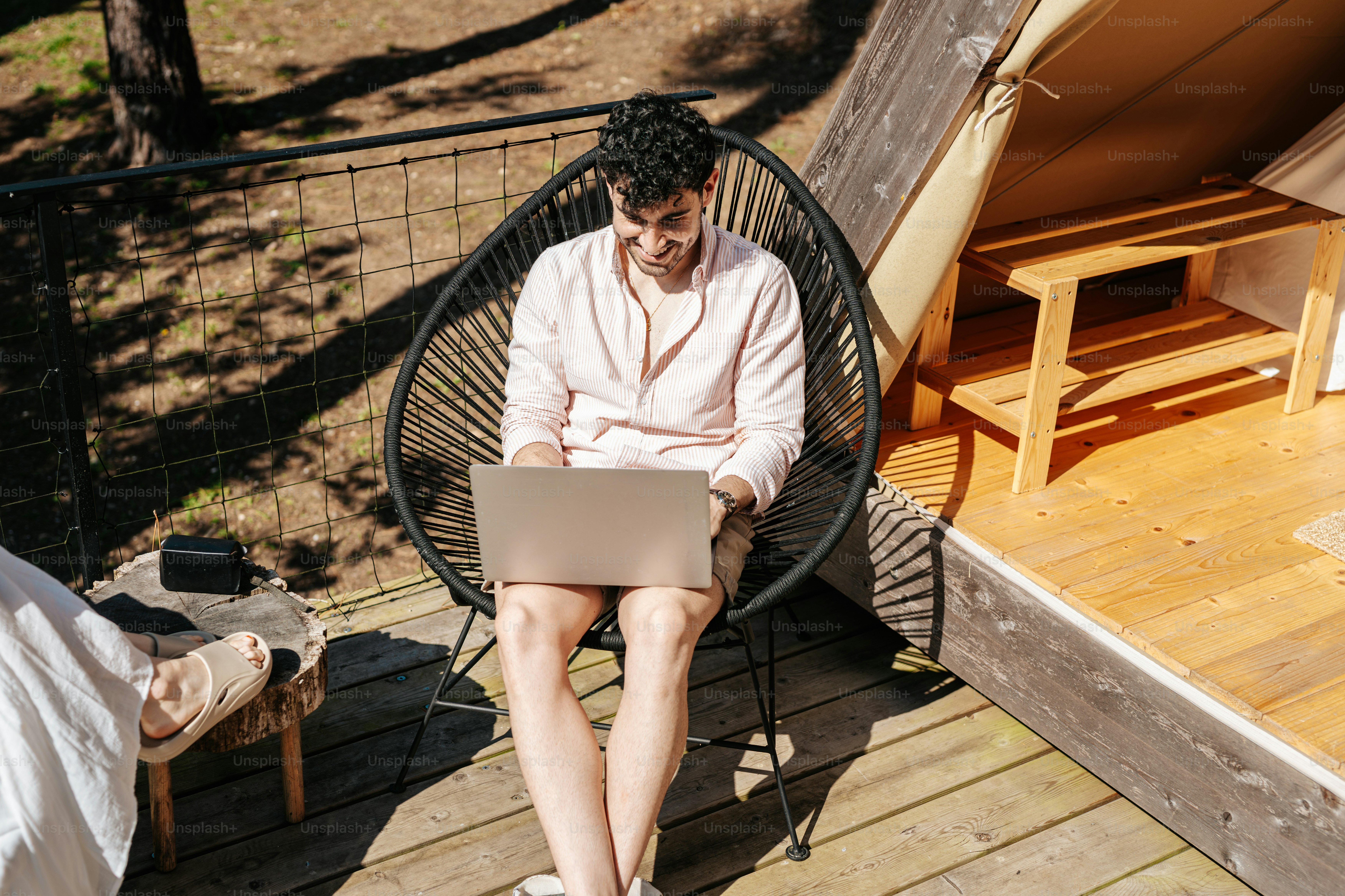 A man sitting in a chair using a laptop computer