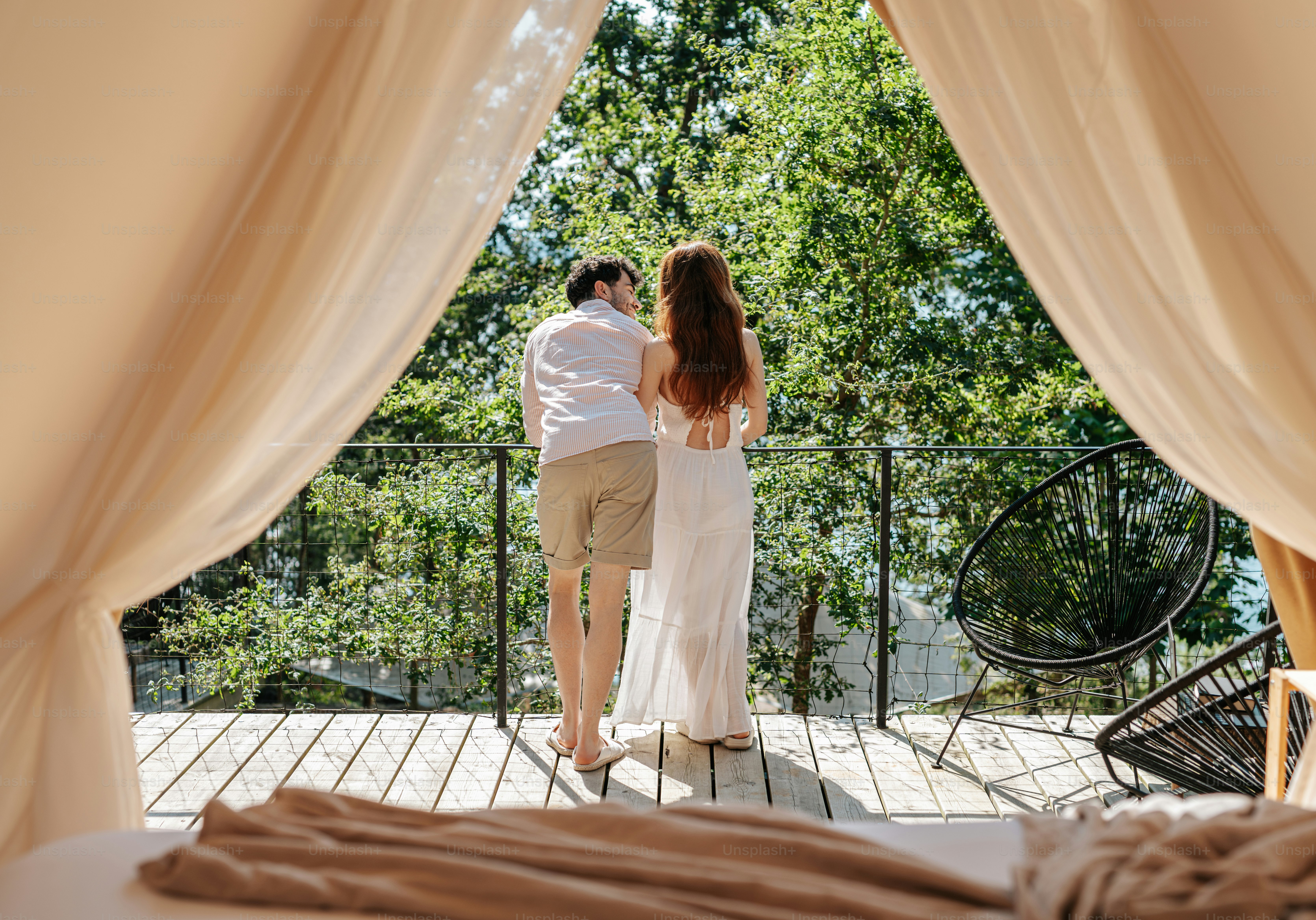 A man and a woman standing in front of a window