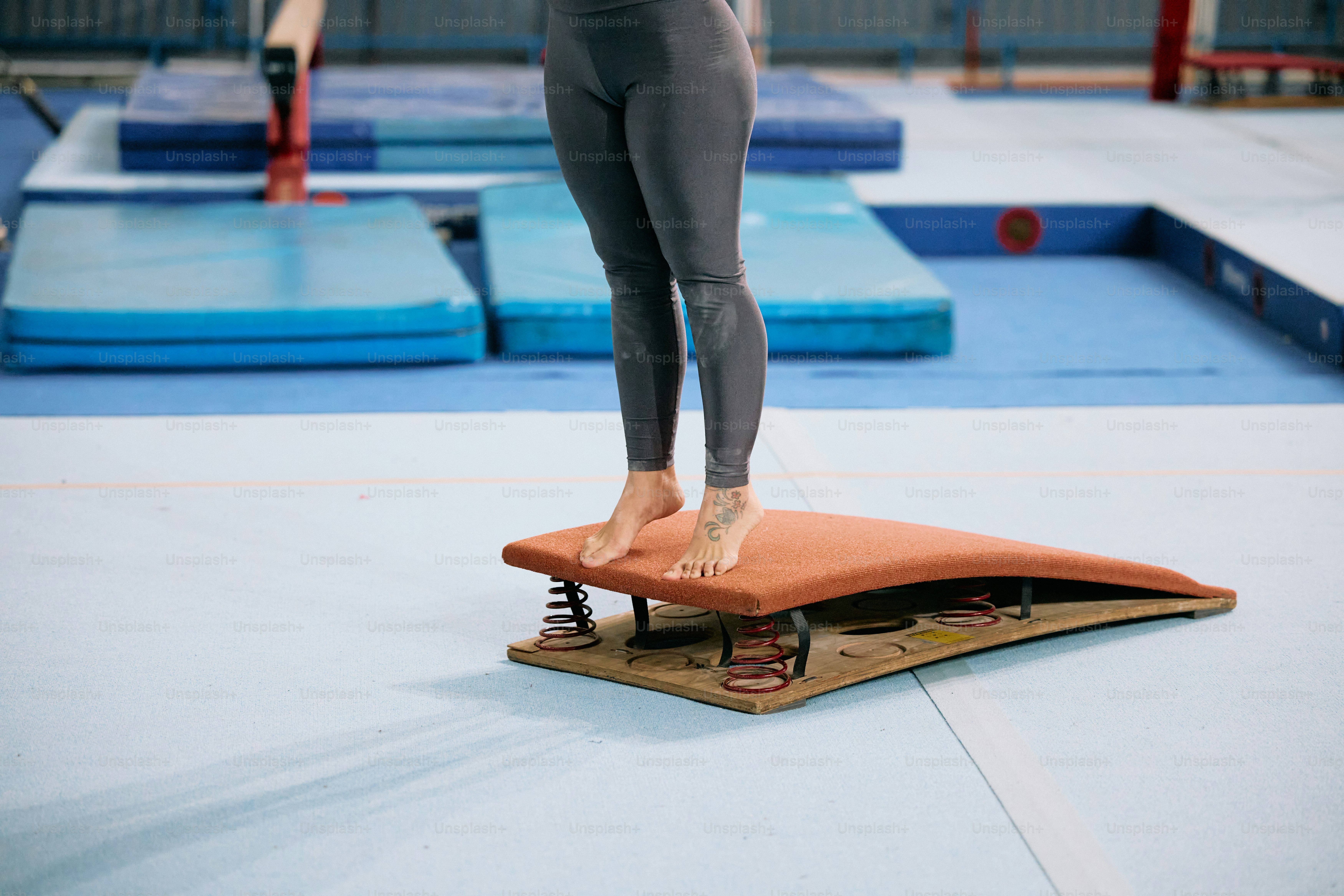 A woman standing on a mat in a gym