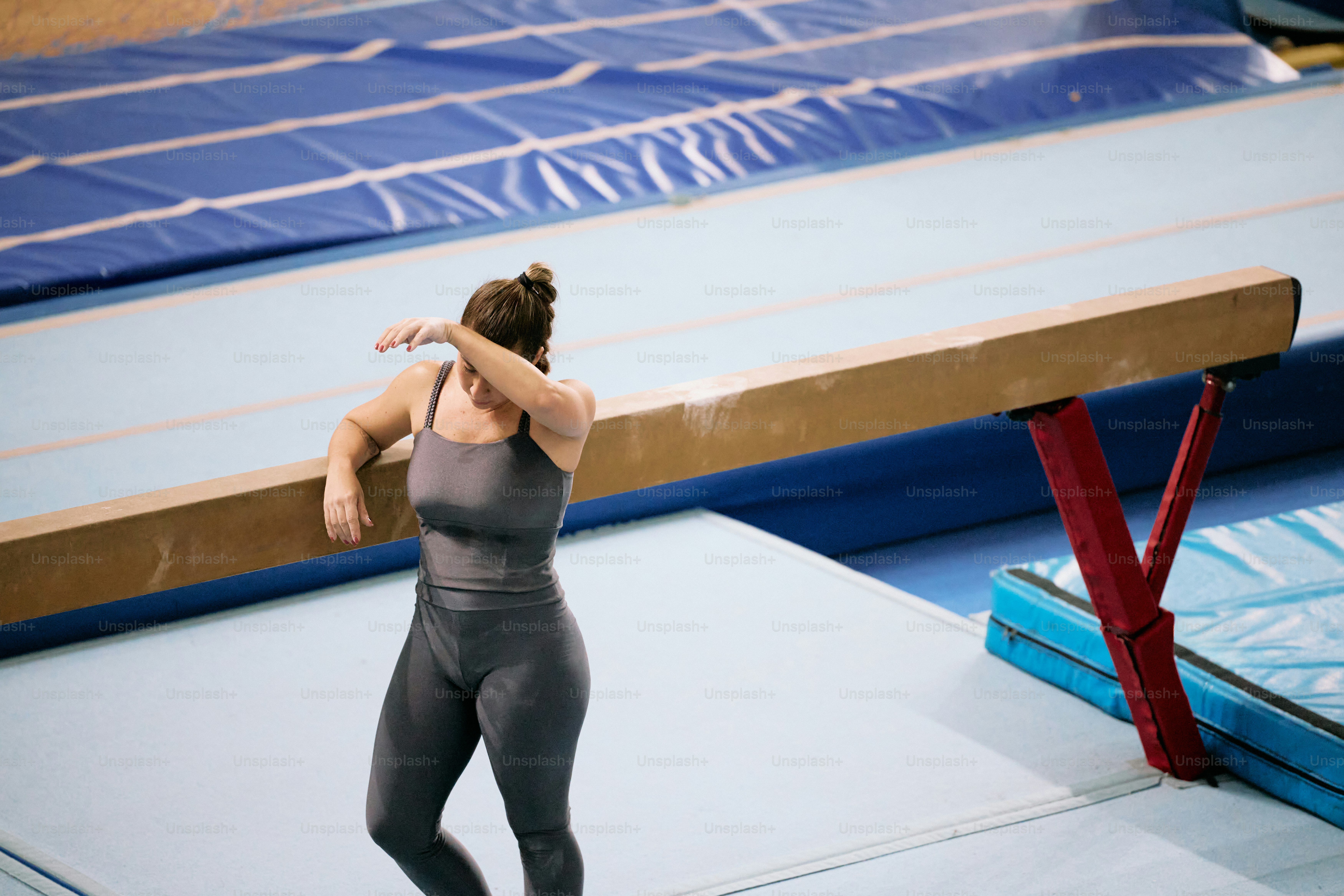 A woman standing on a wrestling mat in a gym