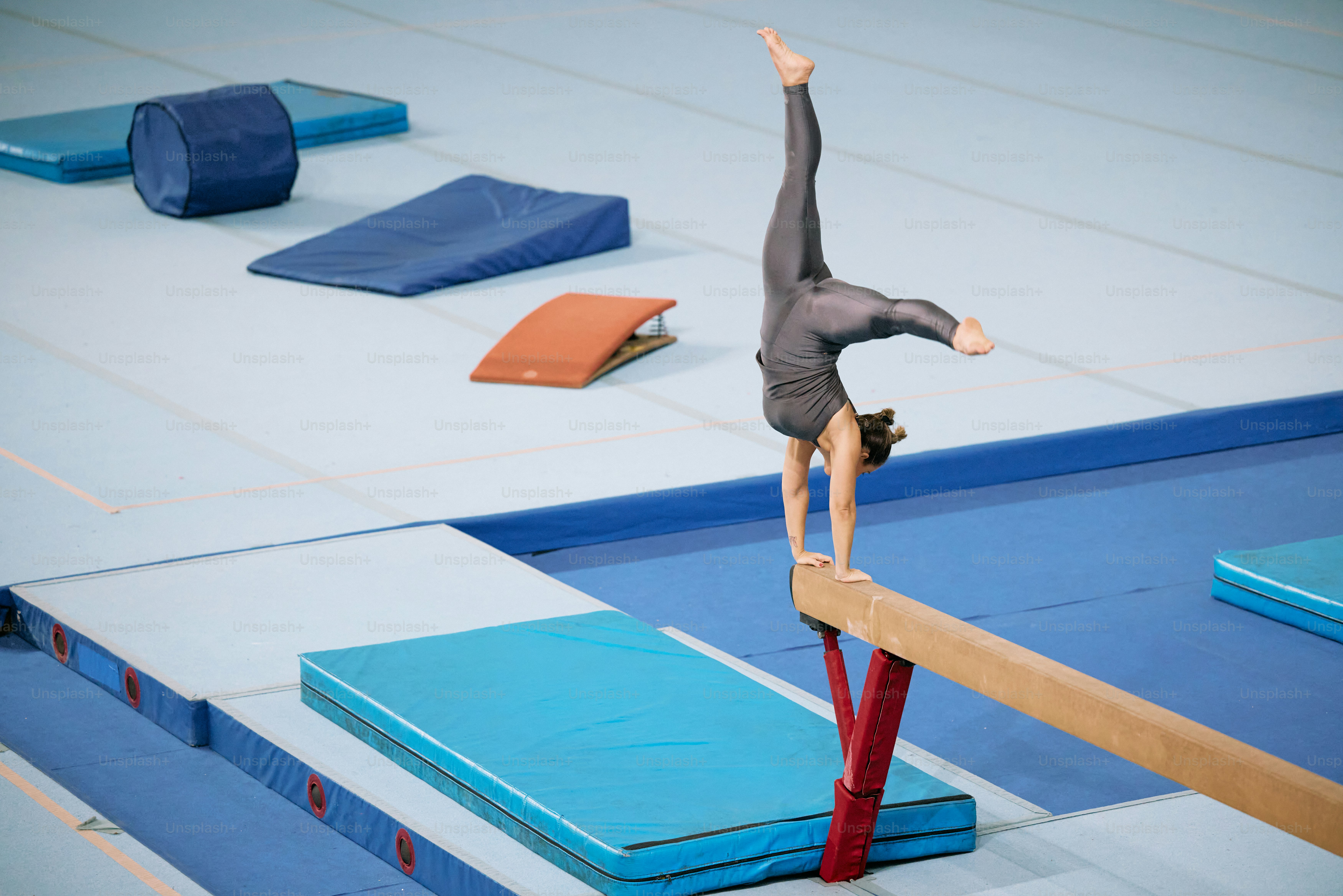 Una persona haciendo una parada de manos en una viga