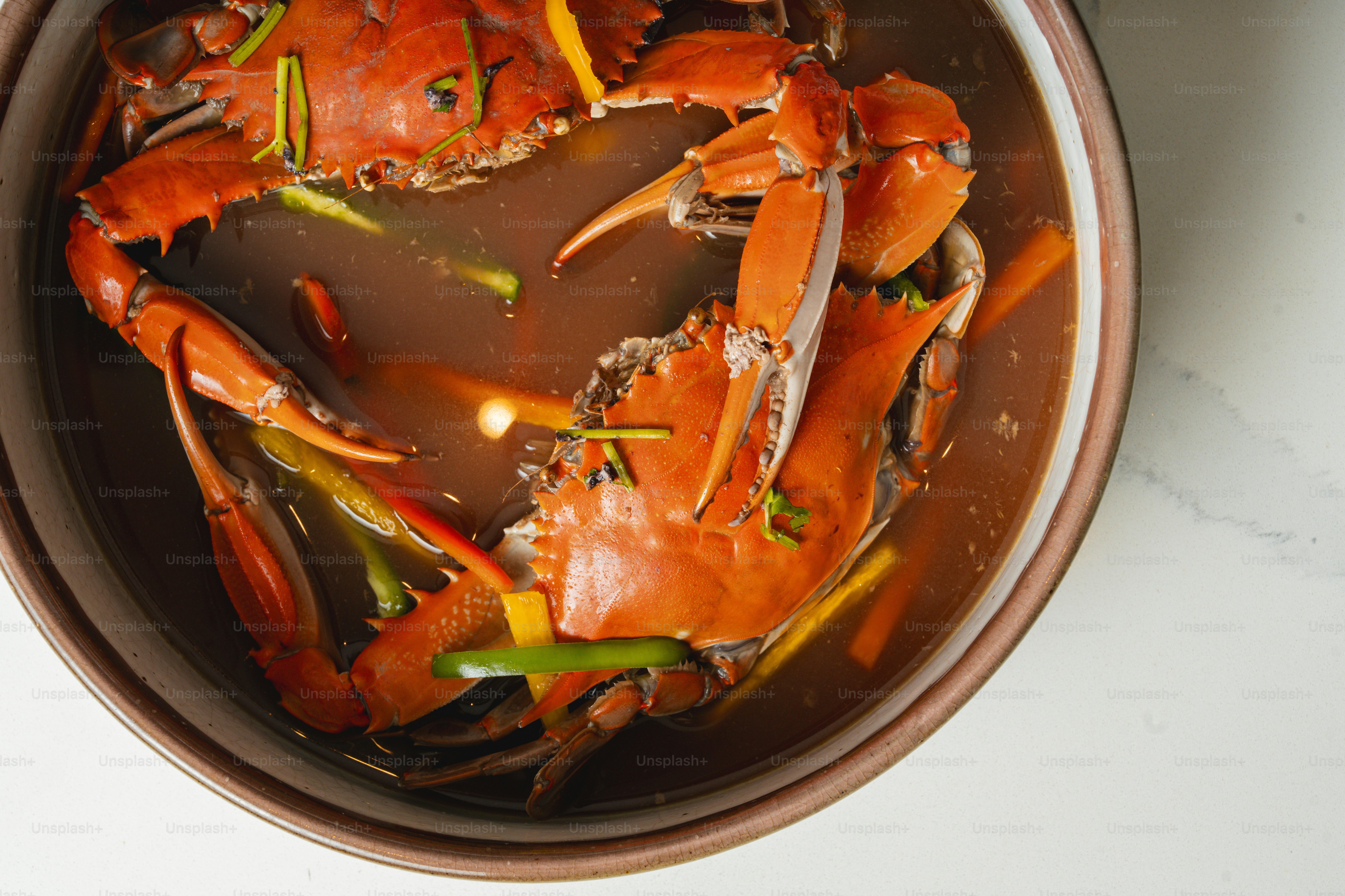 A bowl filled with cooked crabs on top of a table