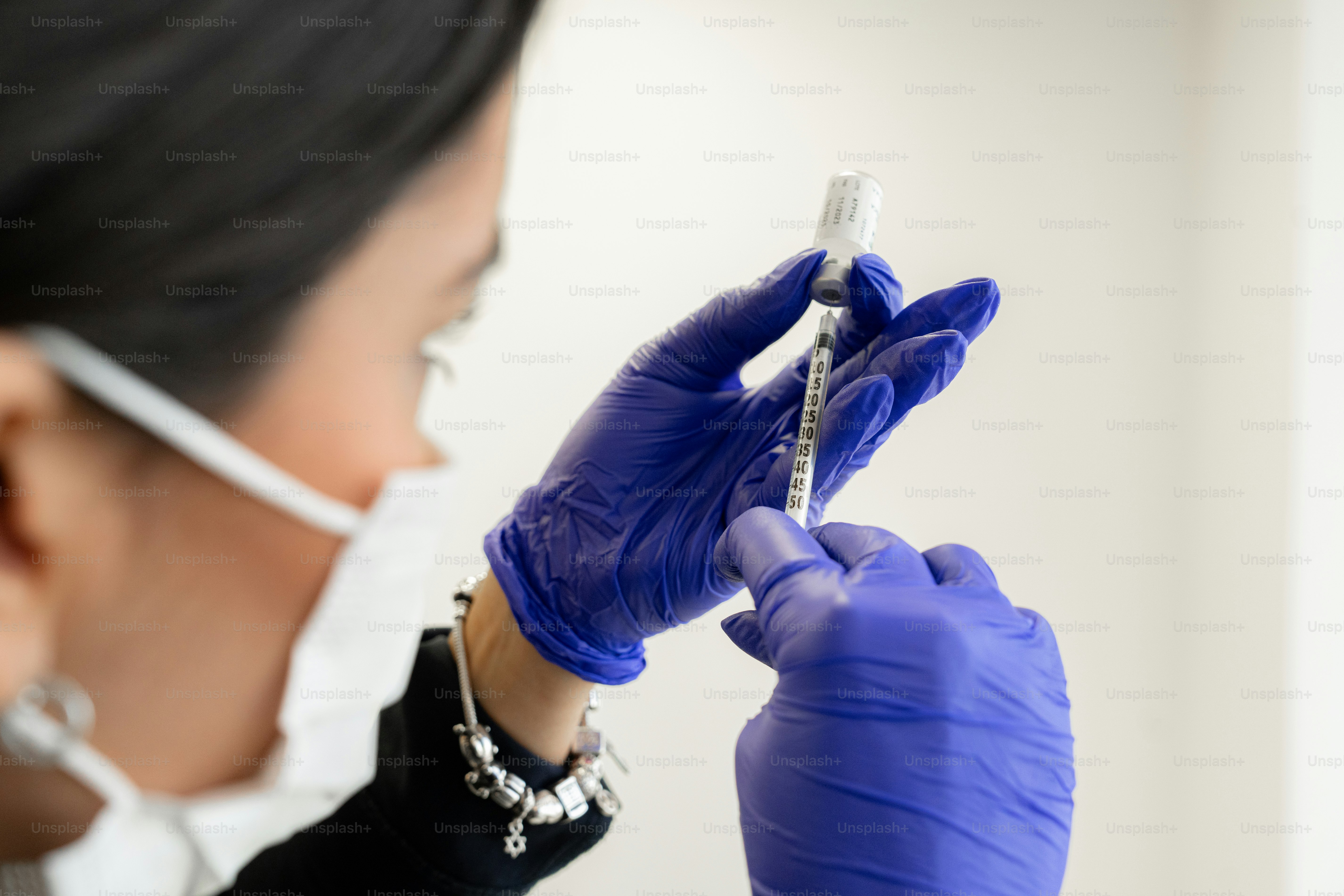 A woman wearing a mask and gloves holding a sys