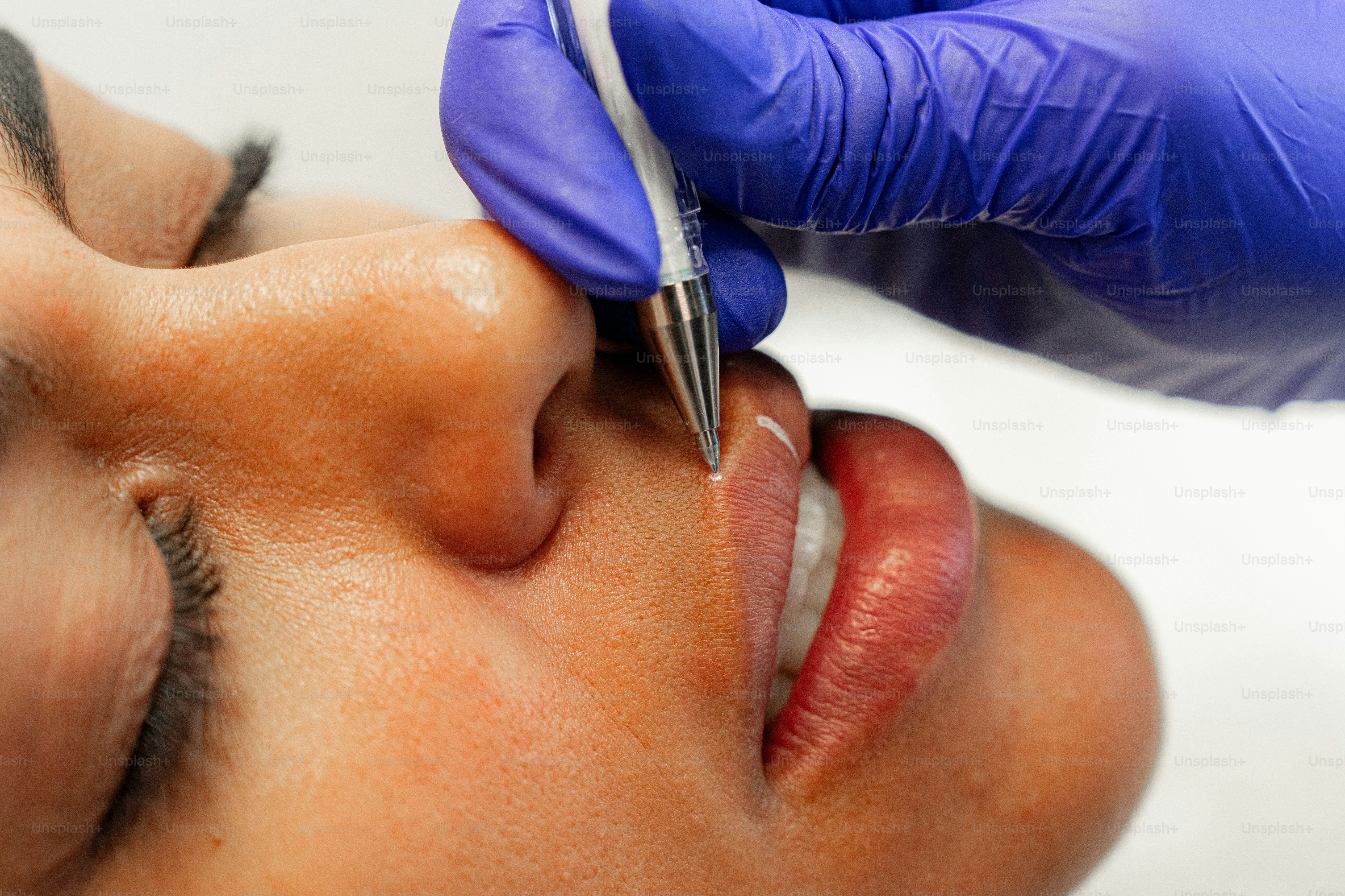 A woman getting a permanent tattoo on her forehead