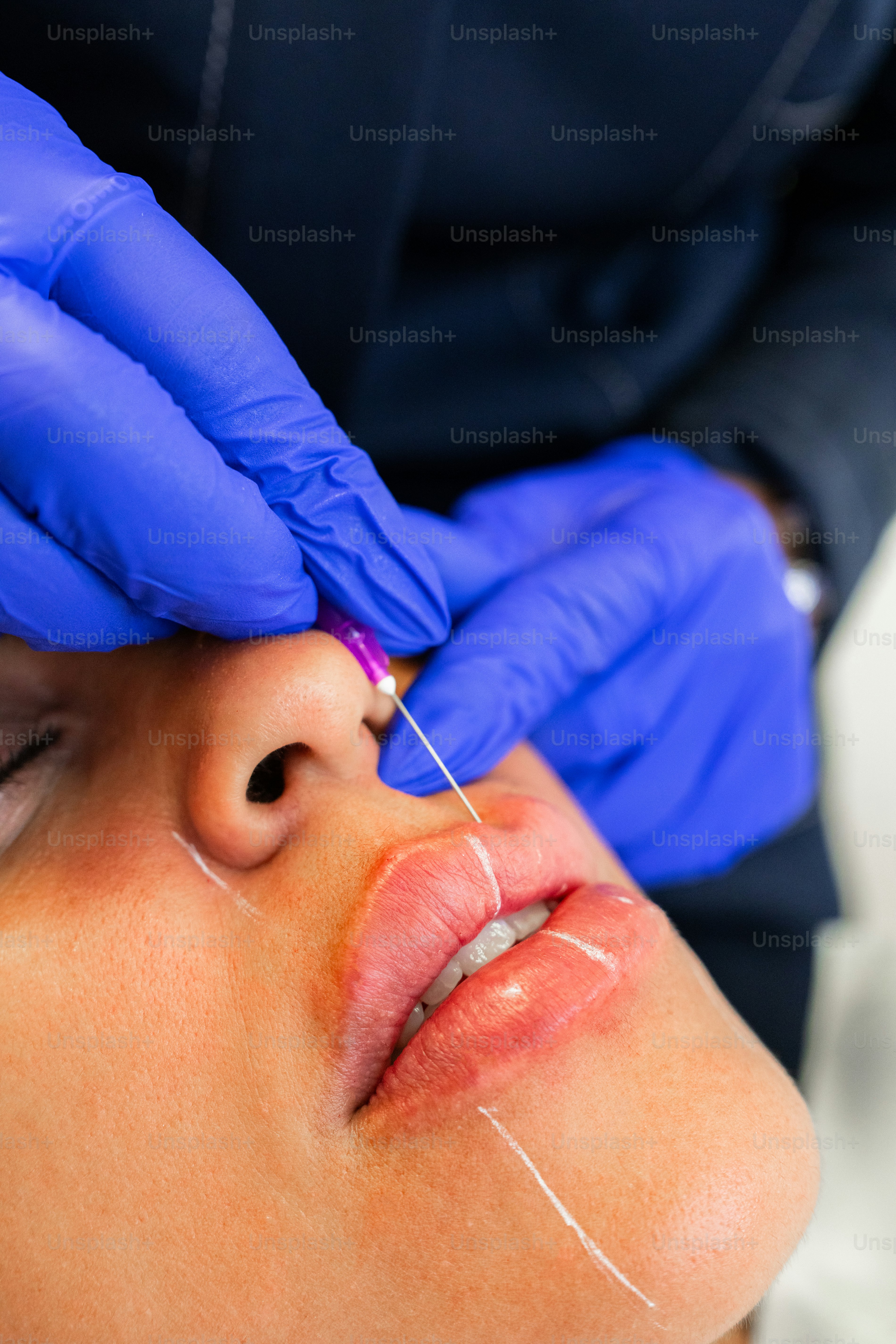 A woman getting her nose examined by a doctor